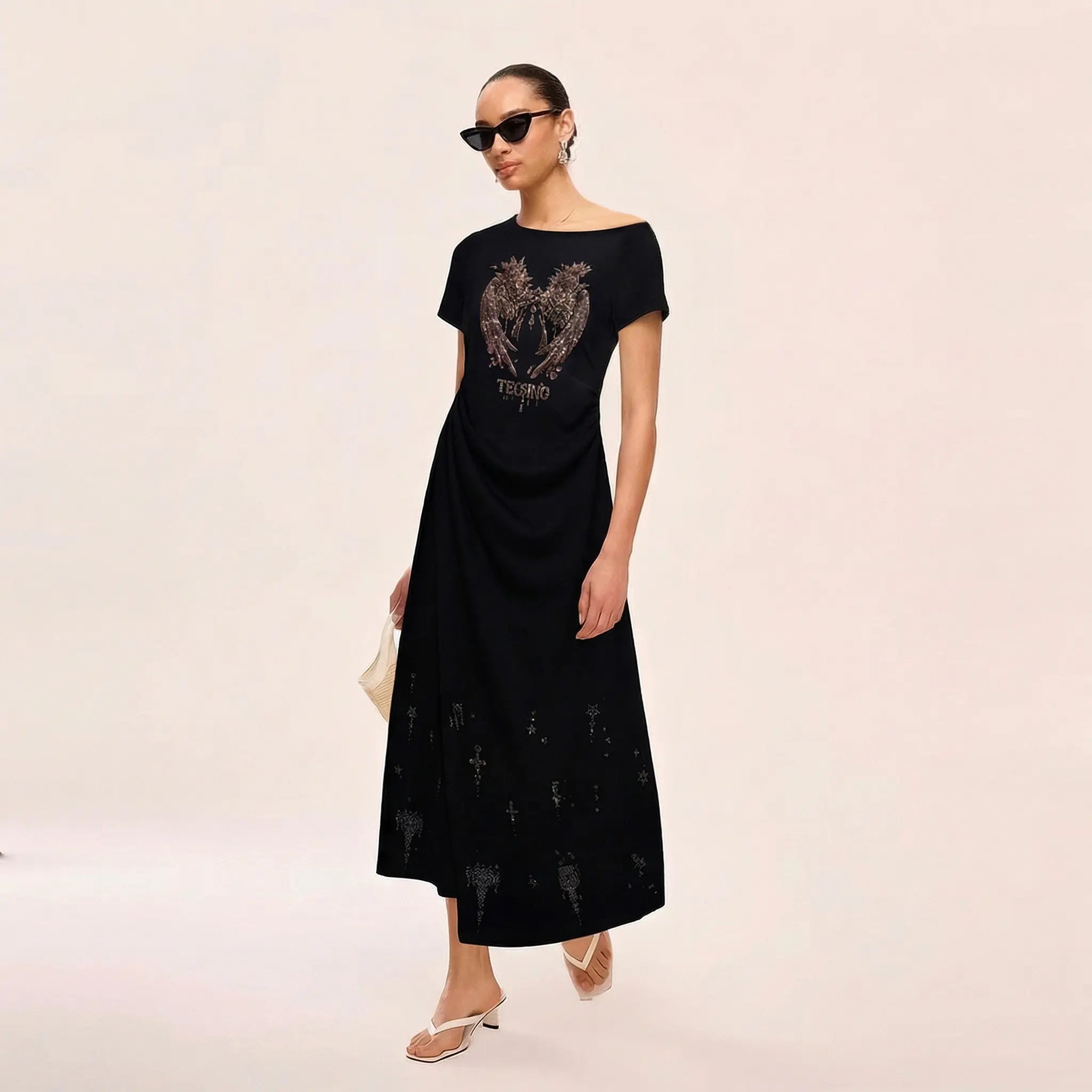 Woman wearing a black dress with a graphic design on a beige background, TCH Rhinestone Angel Wing Black Dress