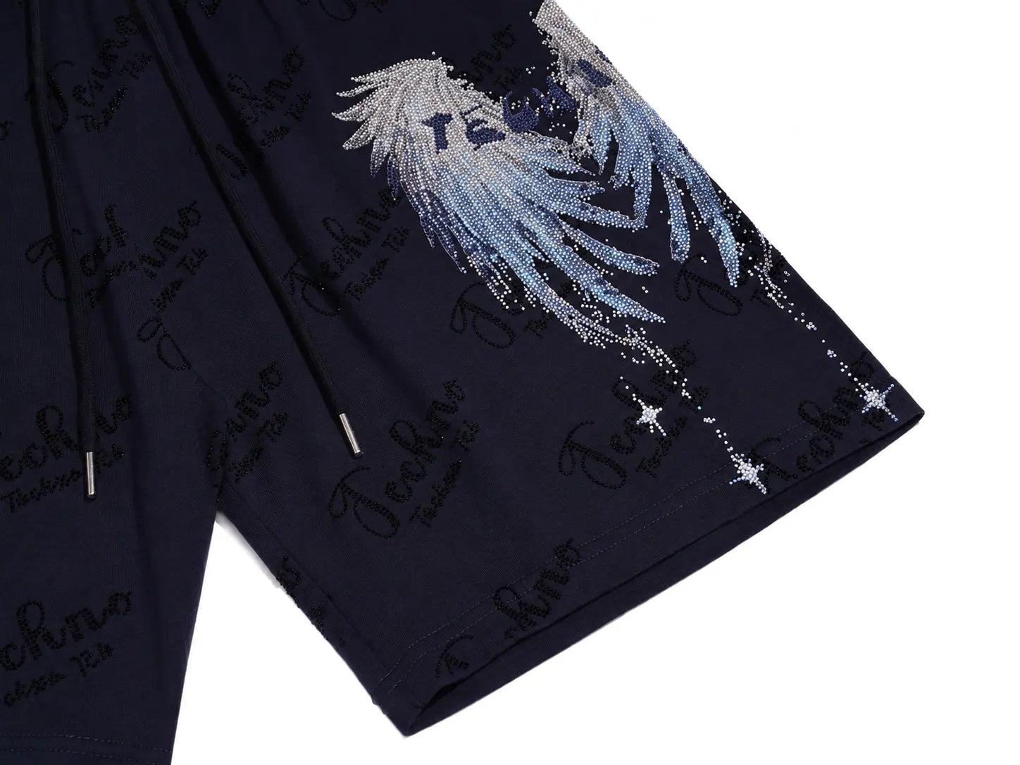 Close-up of dark navy shorts with a large silver angel wing graphic and repeated black script logos, shown on a white background. TCH Rhinestone Angel Wing Gradient Cargo Shorts