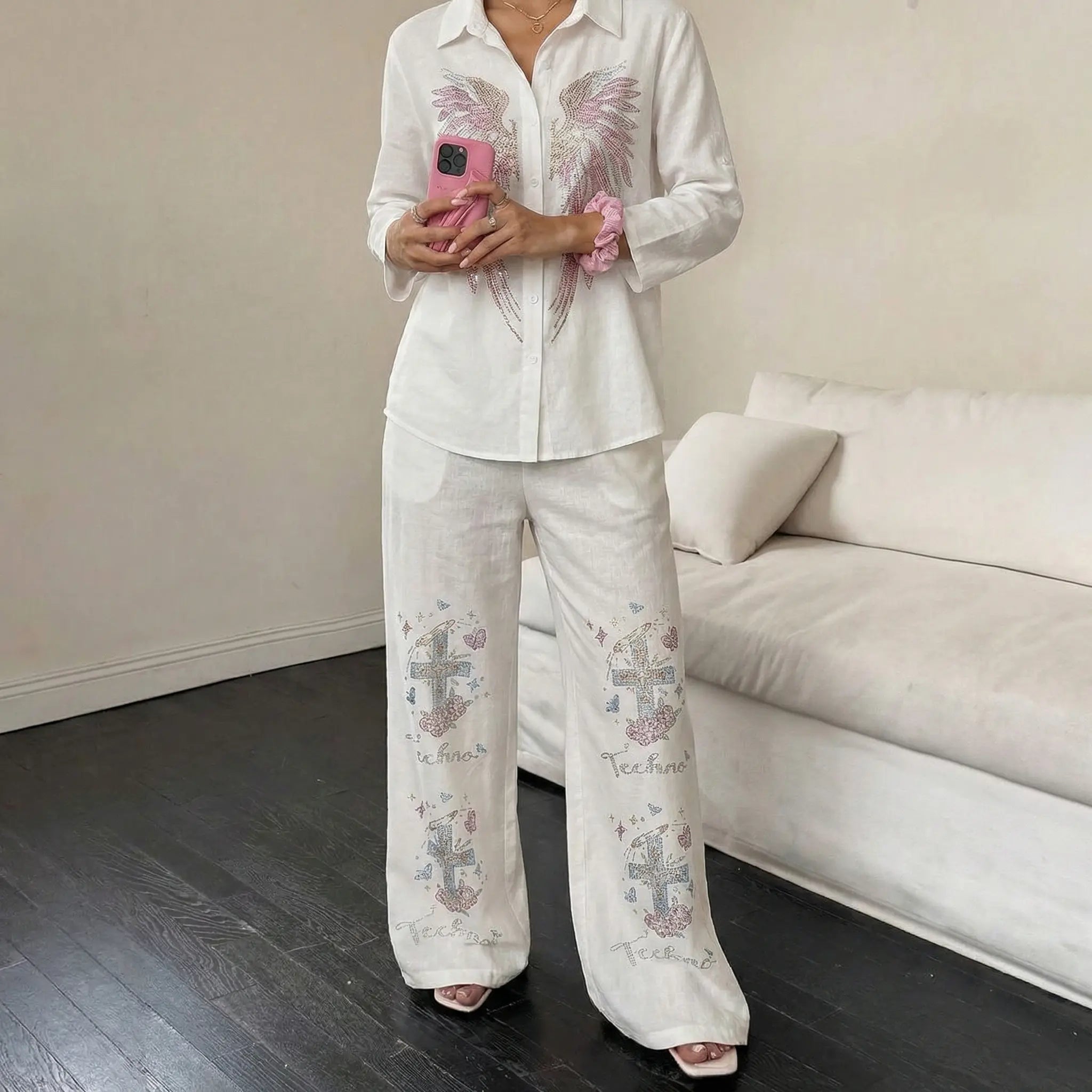 Person wearing a white embroidered outfit in a living room. TCH Rhinestone Angel Wings & Cross Set