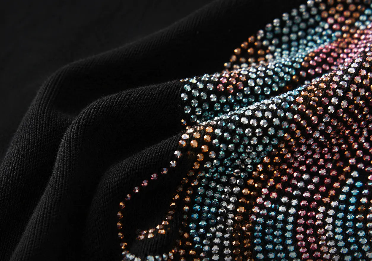 Close-up of a black knit fabric with an intricate, multicolored beaded pattern featuring rows of blue, pink, brown, and silver rhinestones. TCH Rhinestone Angel Wings Graphic T-Shirt