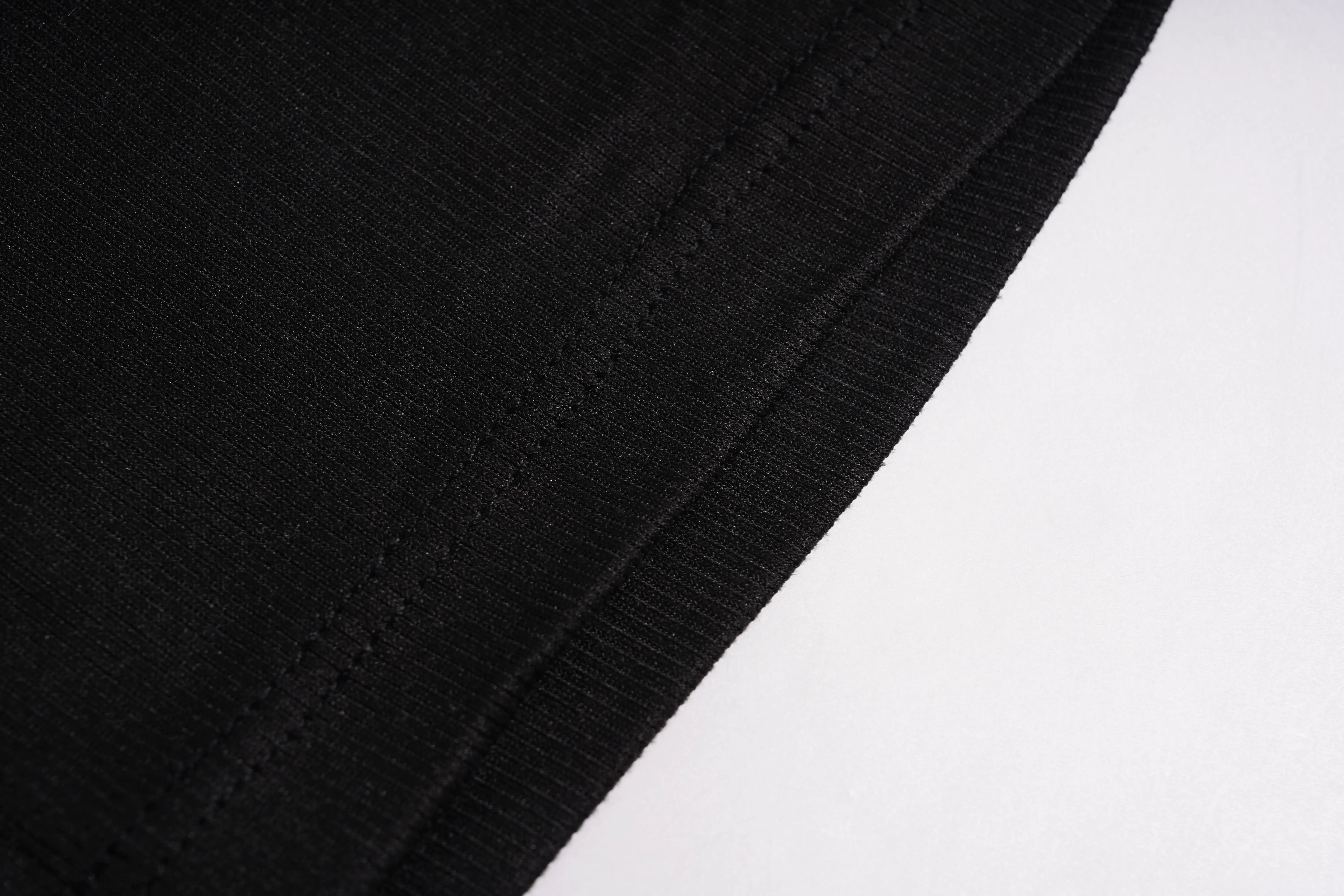 A close-up of dark black ribbed fabric with soft folds and a fine knit texture. TCH Rhinestone Angel Wings Ribbed Tank Top