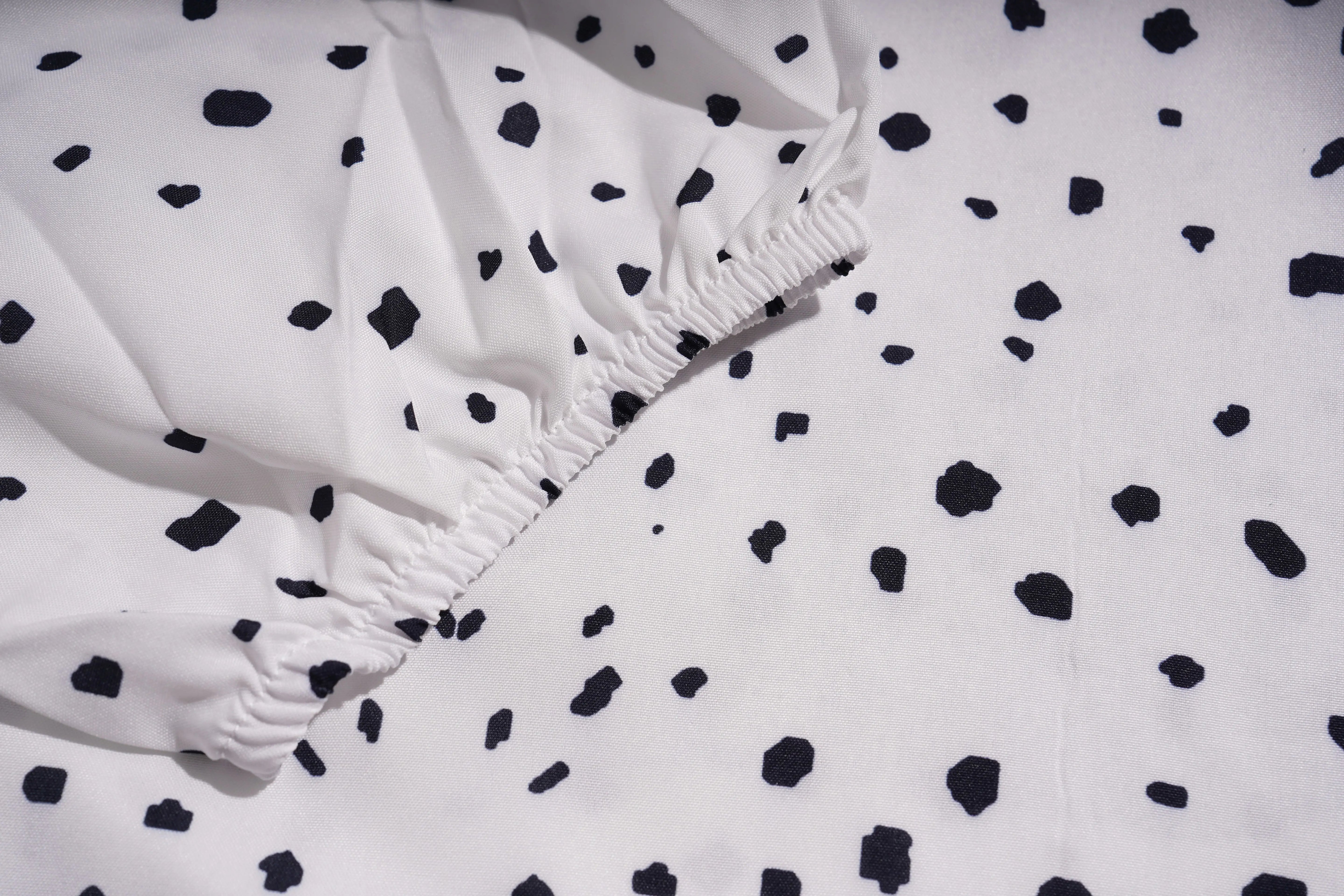 Close-up of a white fabric with black polka dots, TCH Rhinestone Animal Polka Dot Shirt