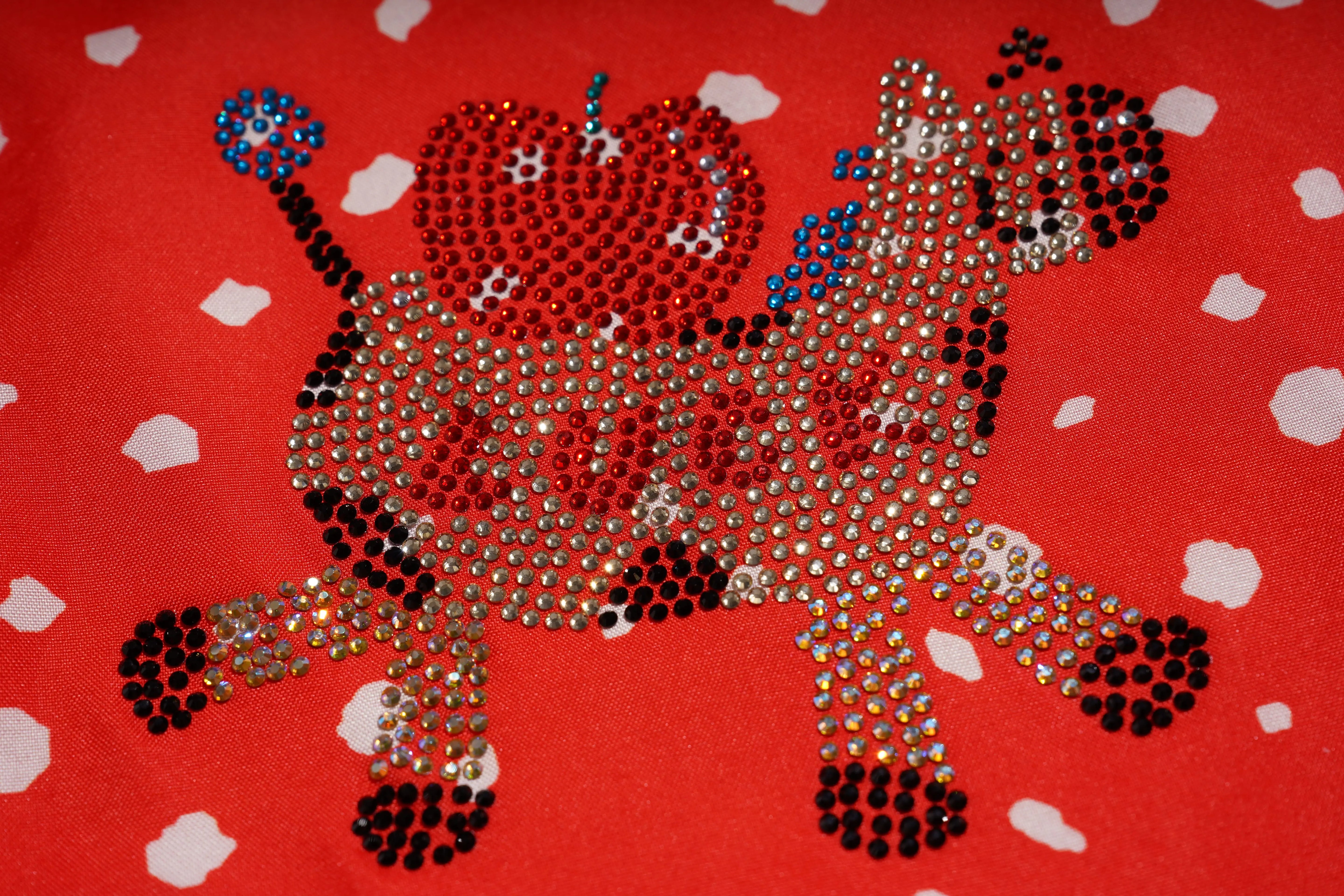 Decorative design of a lion with rhinestones on a red background with white hearts. TCH Rhinestone Animal Polka Dot Shirt
