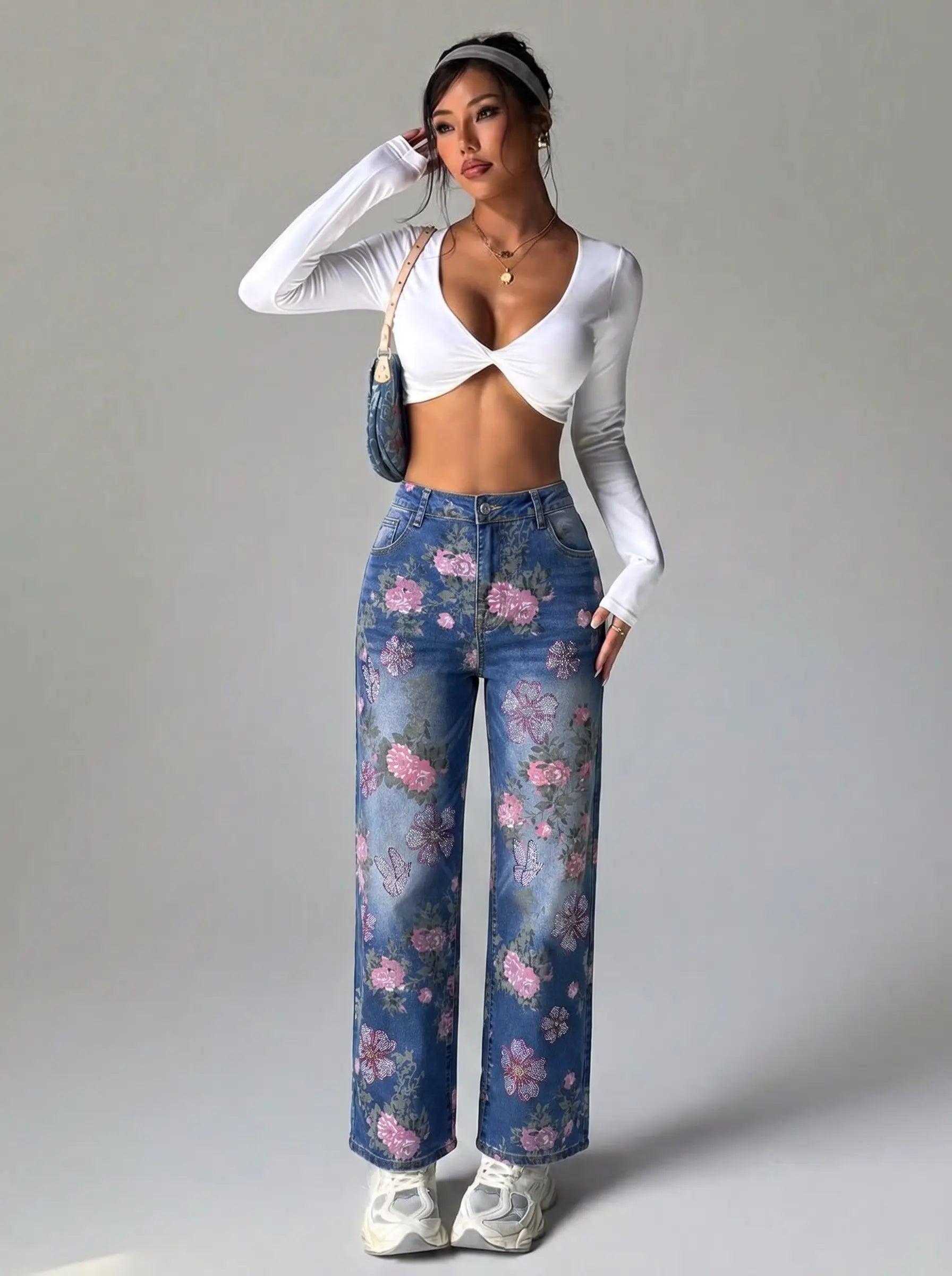 Woman wearing a white long-sleeve top and blue floral pants on a gray background, TCH Rhinestone Blossom Print Denim Jeans