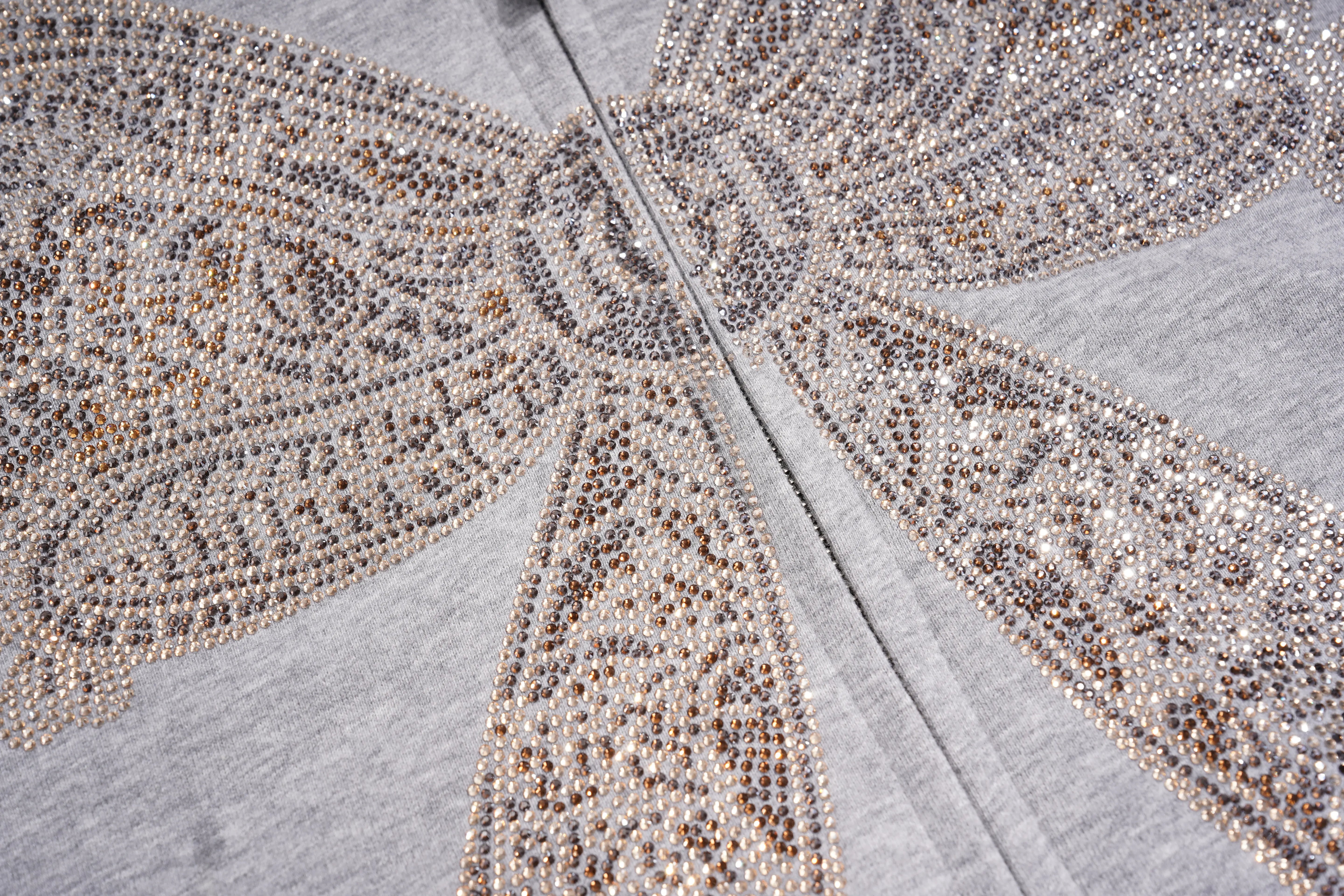 Close-up of a light gray heather fabric with a large embroidered or beaded butterfly motif in metallic silver, champagne, and taupe tones. TCH Rhinestone Bow 3-Piece Lounge Set