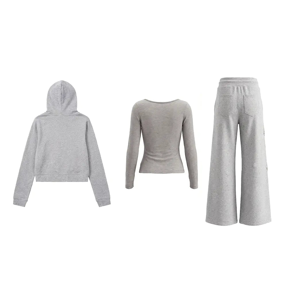 A three-piece women's loungewear set in light heather gray, featuring a cropped hoodie, a long-sleeve scoop-neck top, and wide-leg sweatpants, displayed on invisible mannequins against a plain white background. TCH Rhinestone Bow 3-Piece Lounge Set