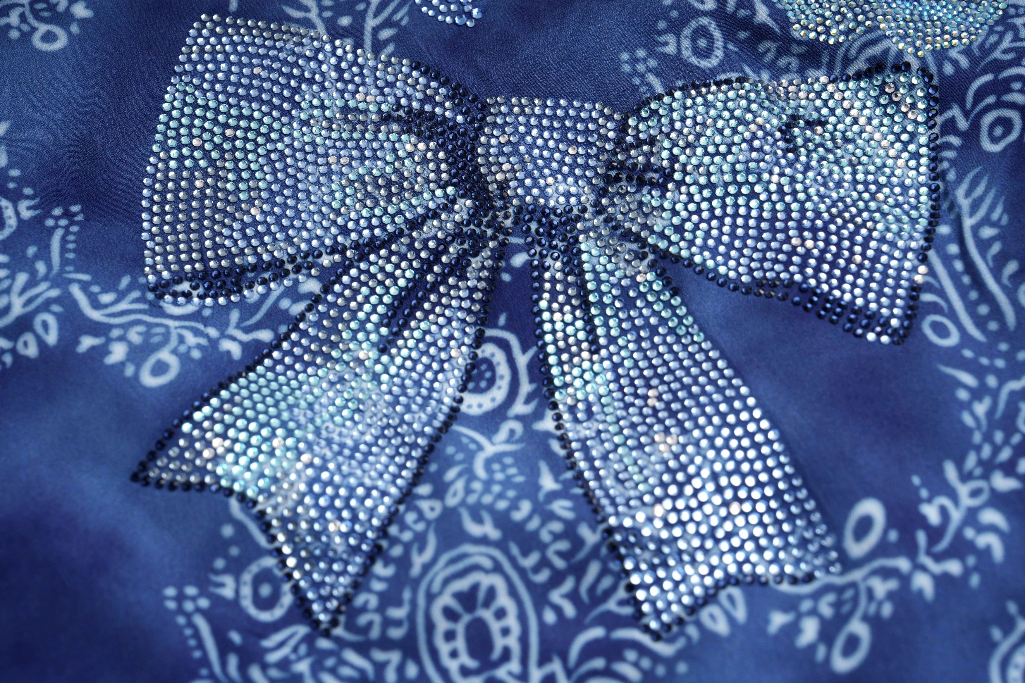 Decorative bow with rhinestones on a blue patterned fabric background, TCH Rhinestone Bow & Floral Blue Dress