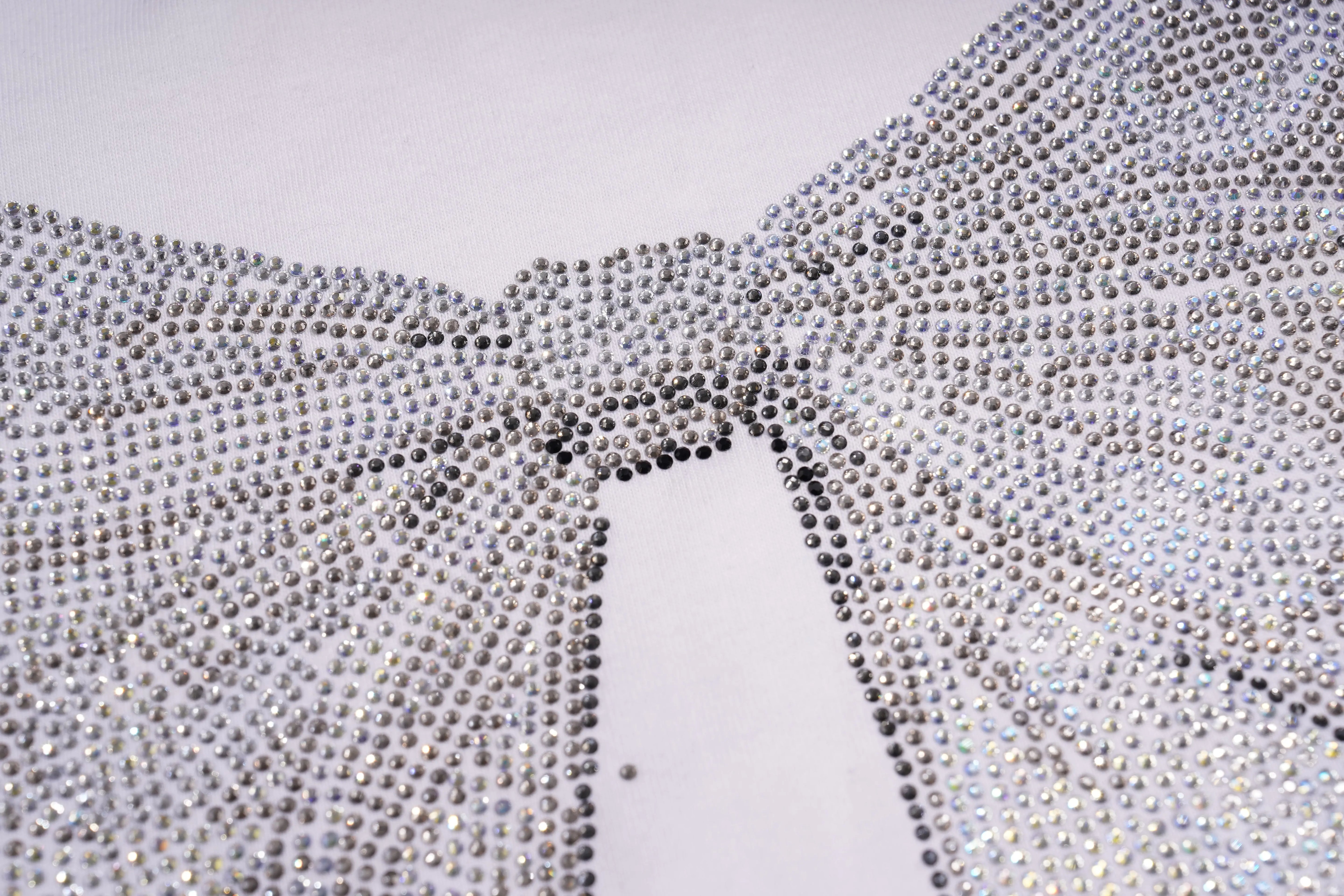 Close-up of a rhinestone-embellished fabric with a bow detail on a white background, TCH Rhinestone Bow White T-Shirt