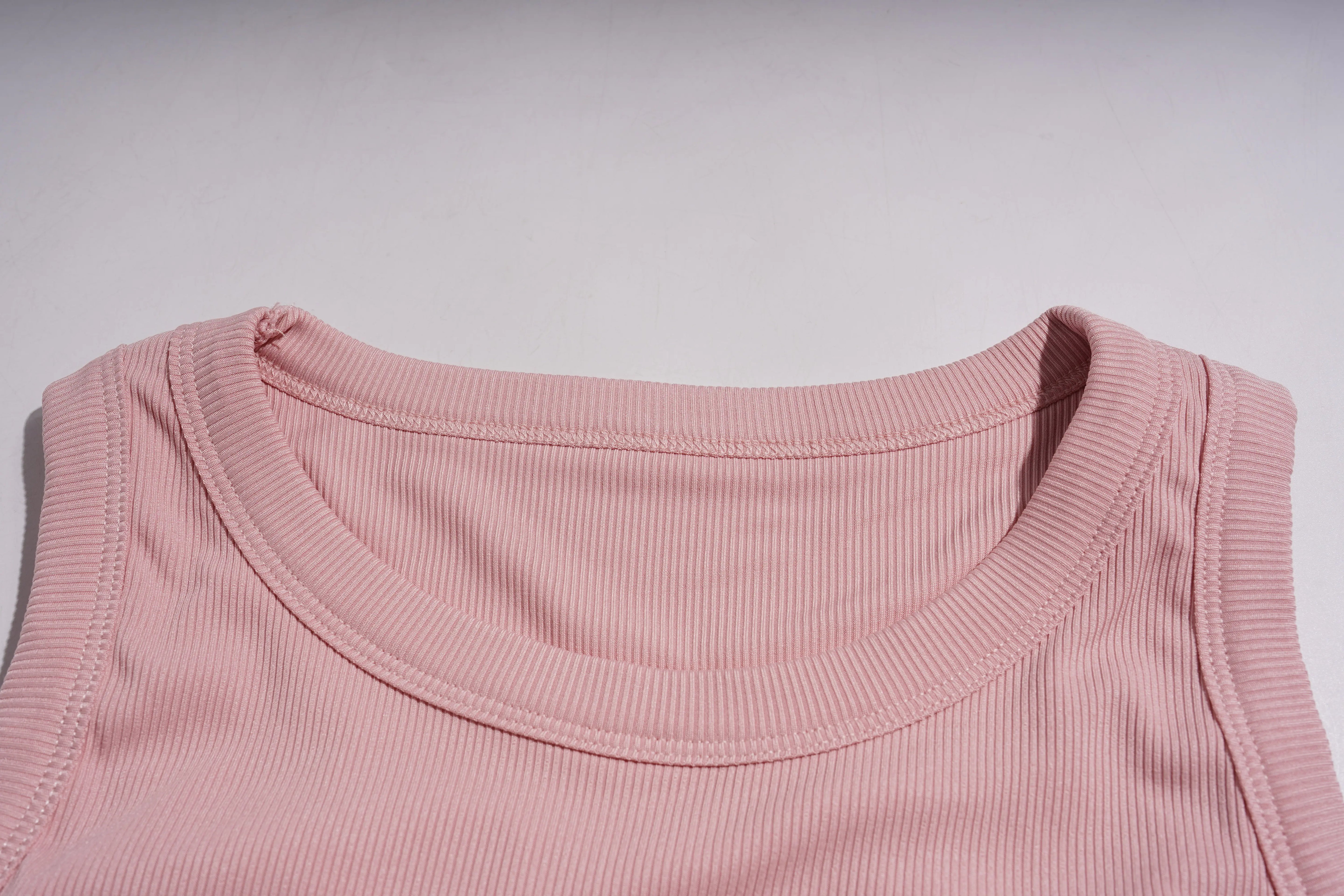 Close-up of a pink ribbed tank top collar on a light gray background, TCH Rhinestone Butterfly Bow Tank Top