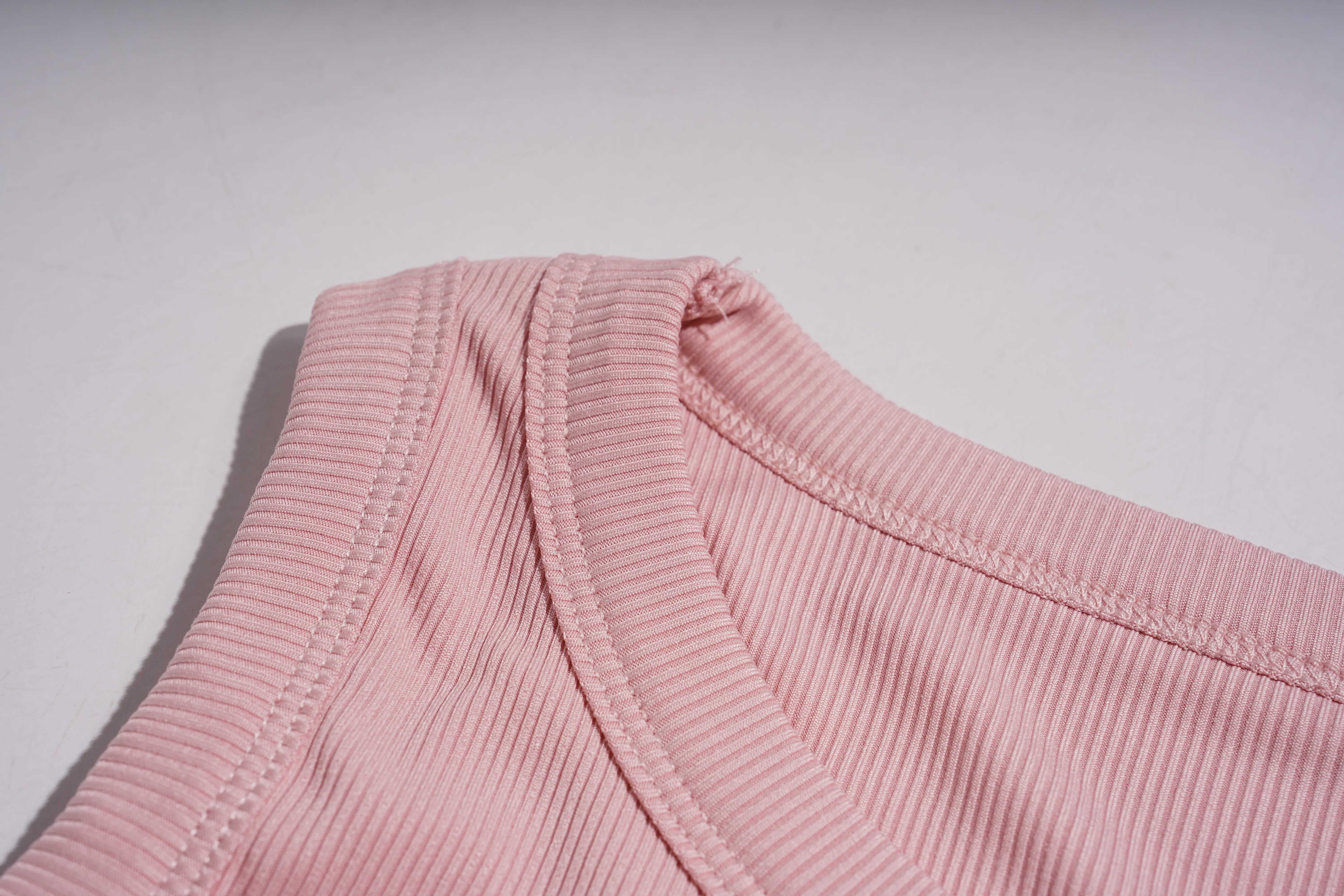Close-up of pink ribbed fabric on a light gray background, TCH Rhinestone Butterfly Bow Tank Top