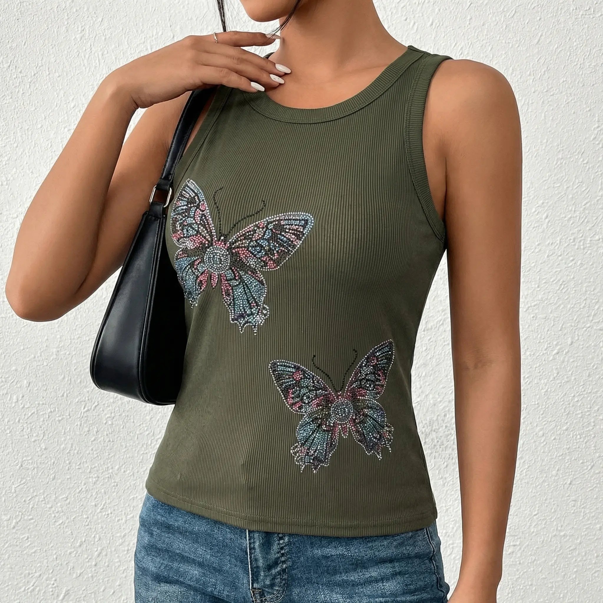 Person wearing a green tank top with butterfly designs against a white background, TCH Rhinestone Butterfly Bow Tank Top