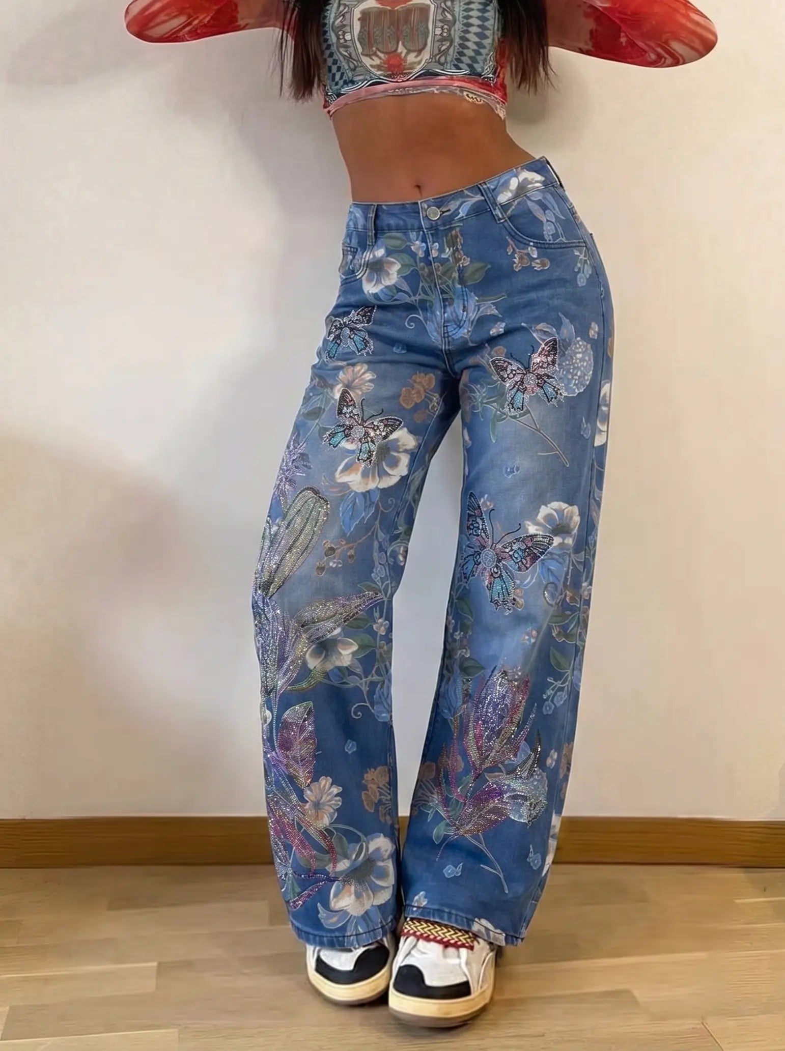 Person wearing a floral top and blue floral pants against a plain background, TCH Rhinestone Butterfly Floral Print Denim Jeans