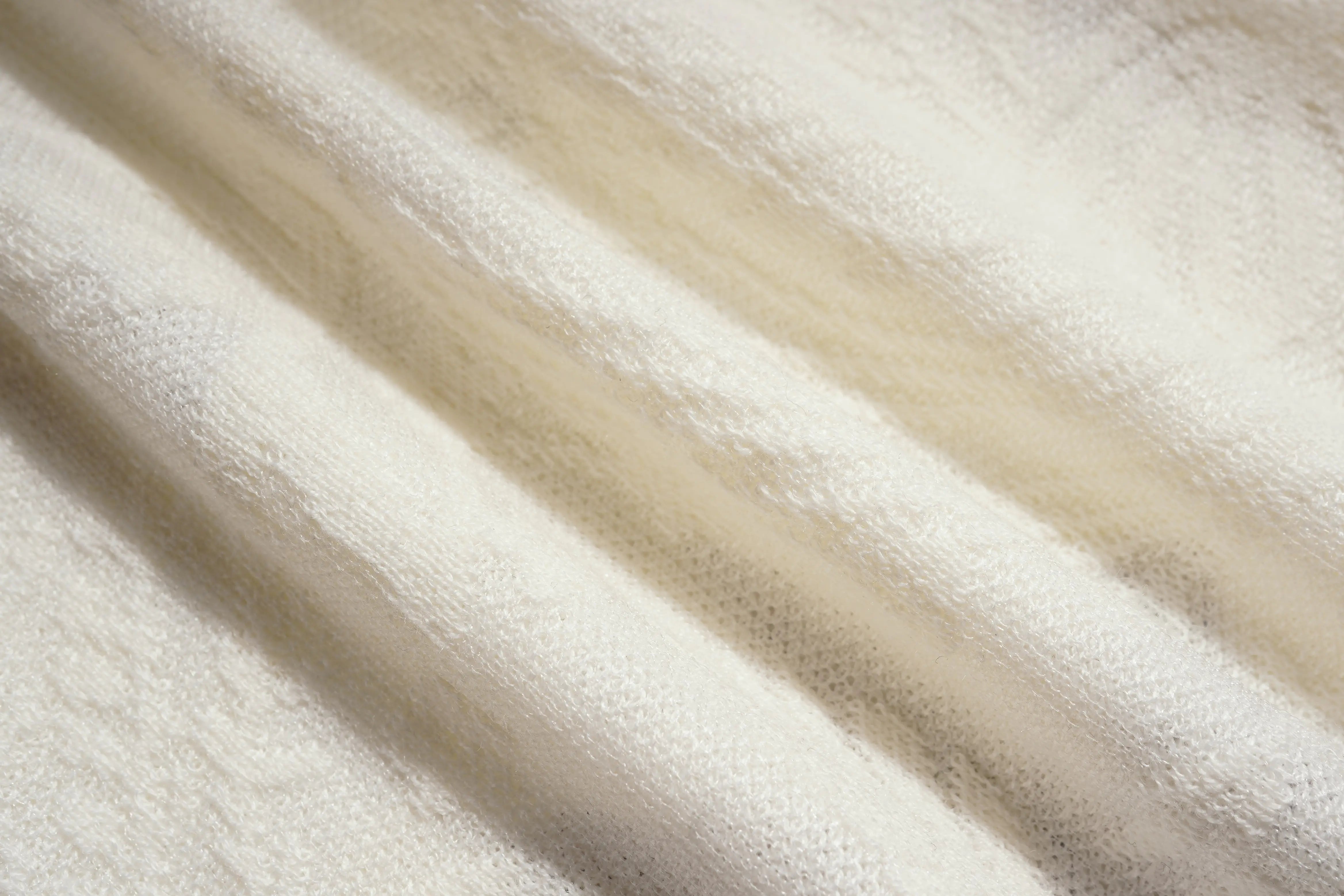 Close-up of beige fabric with a soft texture, TCH Rhinestone Butterfly Logo Knit Cardigan