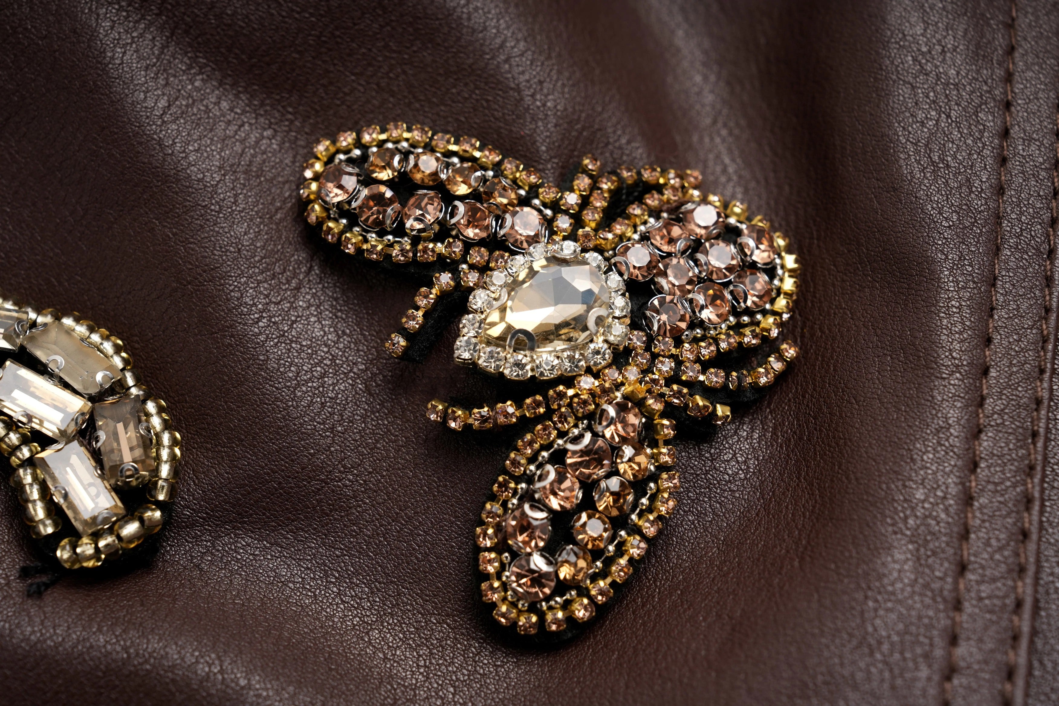 Decorative brooch with gemstones on a brown leather surface, TCH Rhinestone Charm Faux Leather Brown Shorts