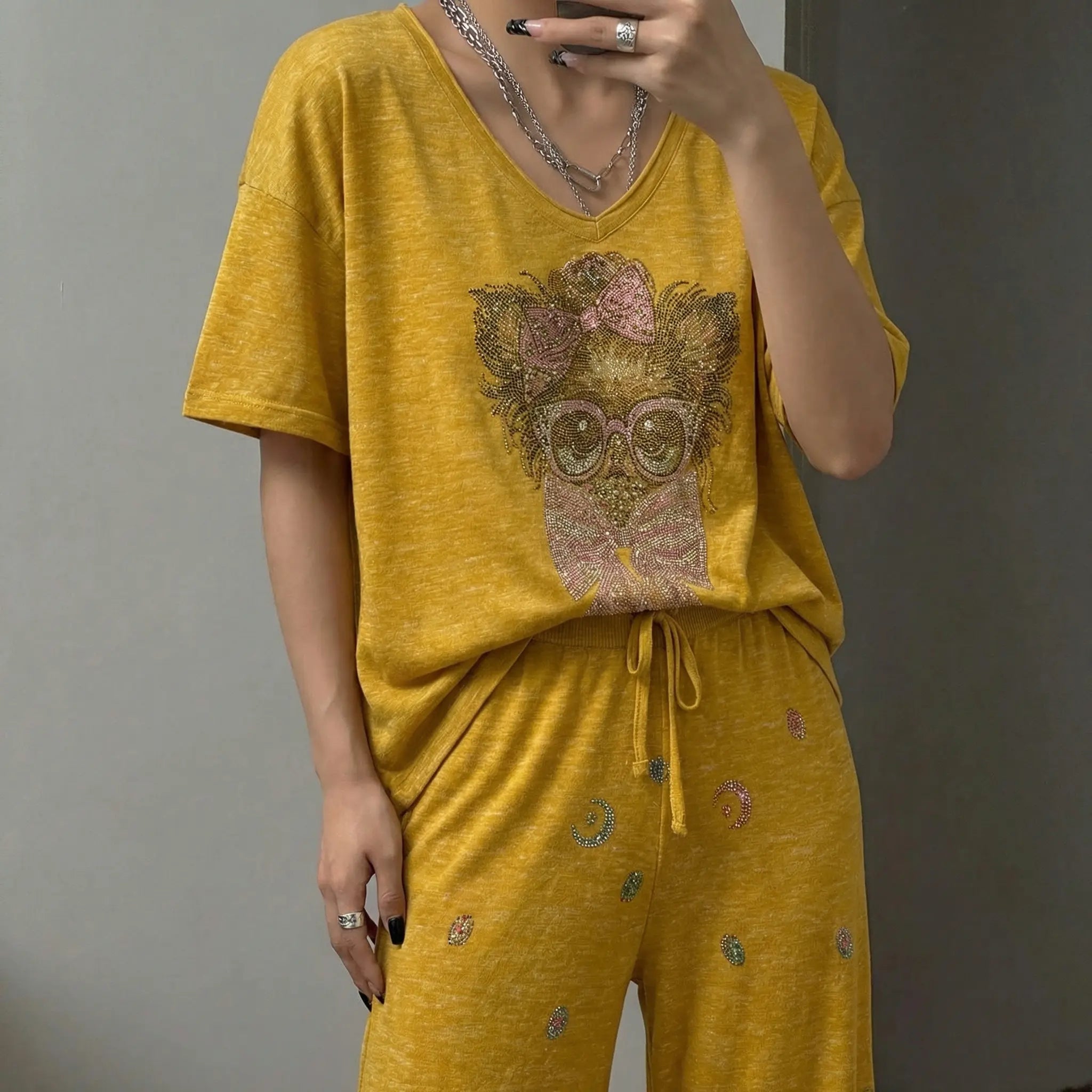 Person wearing a mustard yellow outfit with a dog graphic design, standing against a plain background. TCH Rhinestone Chihuahua Galaxy Set