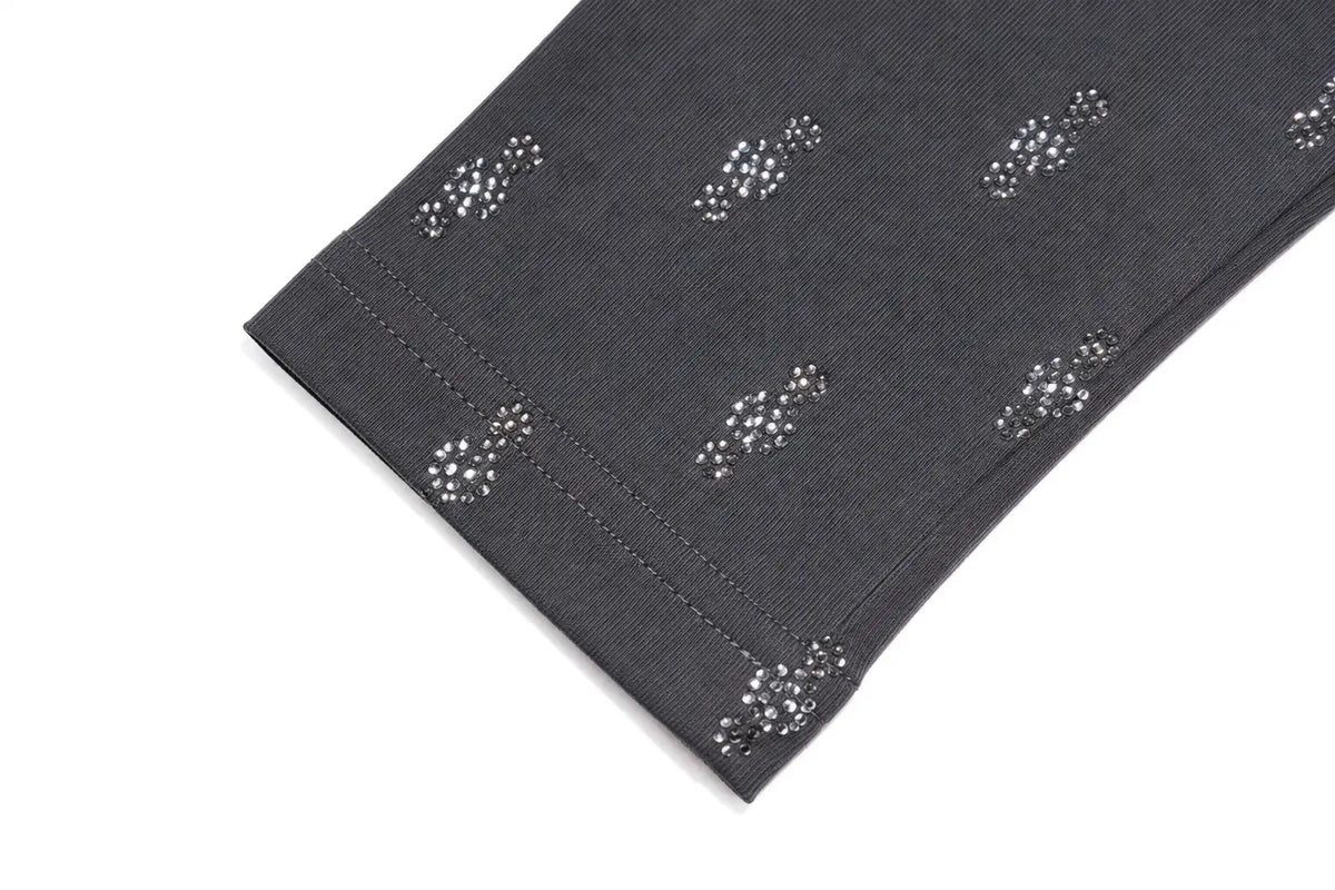 A close-up of a dark gray fabric cuff with a repeating pattern of small silver rhinestone clusters, shown on a plain white background. TCH Rhinestone Cross Graphic Fitted Long Sleeve Top
