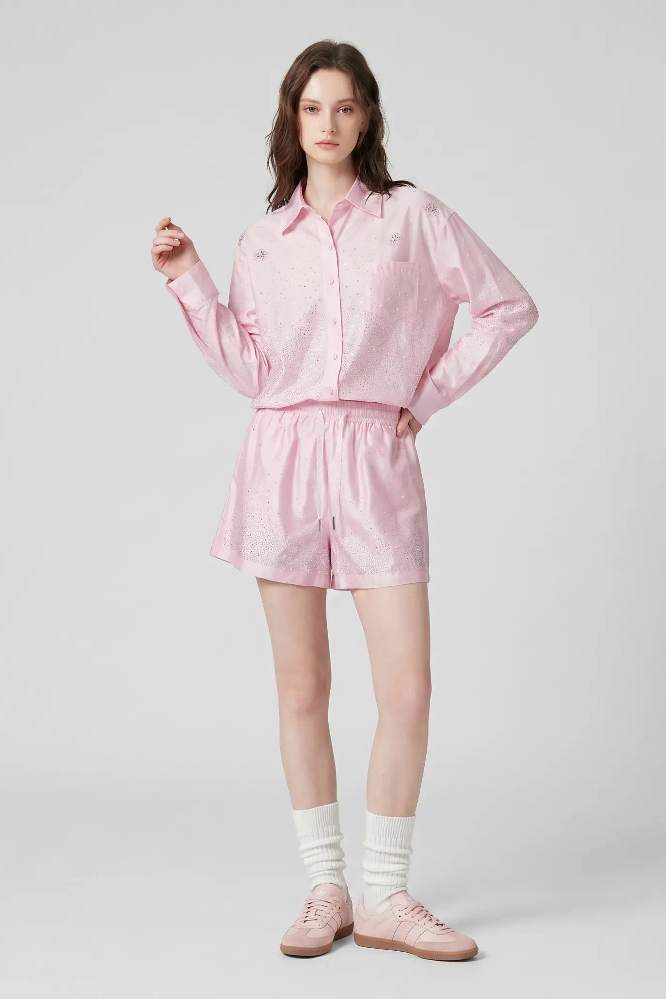 A model stands against a light gray studio background wearing a light pink striped button-up shirt and matching shorts, with white socks and pink shoes. TCH Rhinestone Crystal Embellished Pink Shirt & Shorts Set