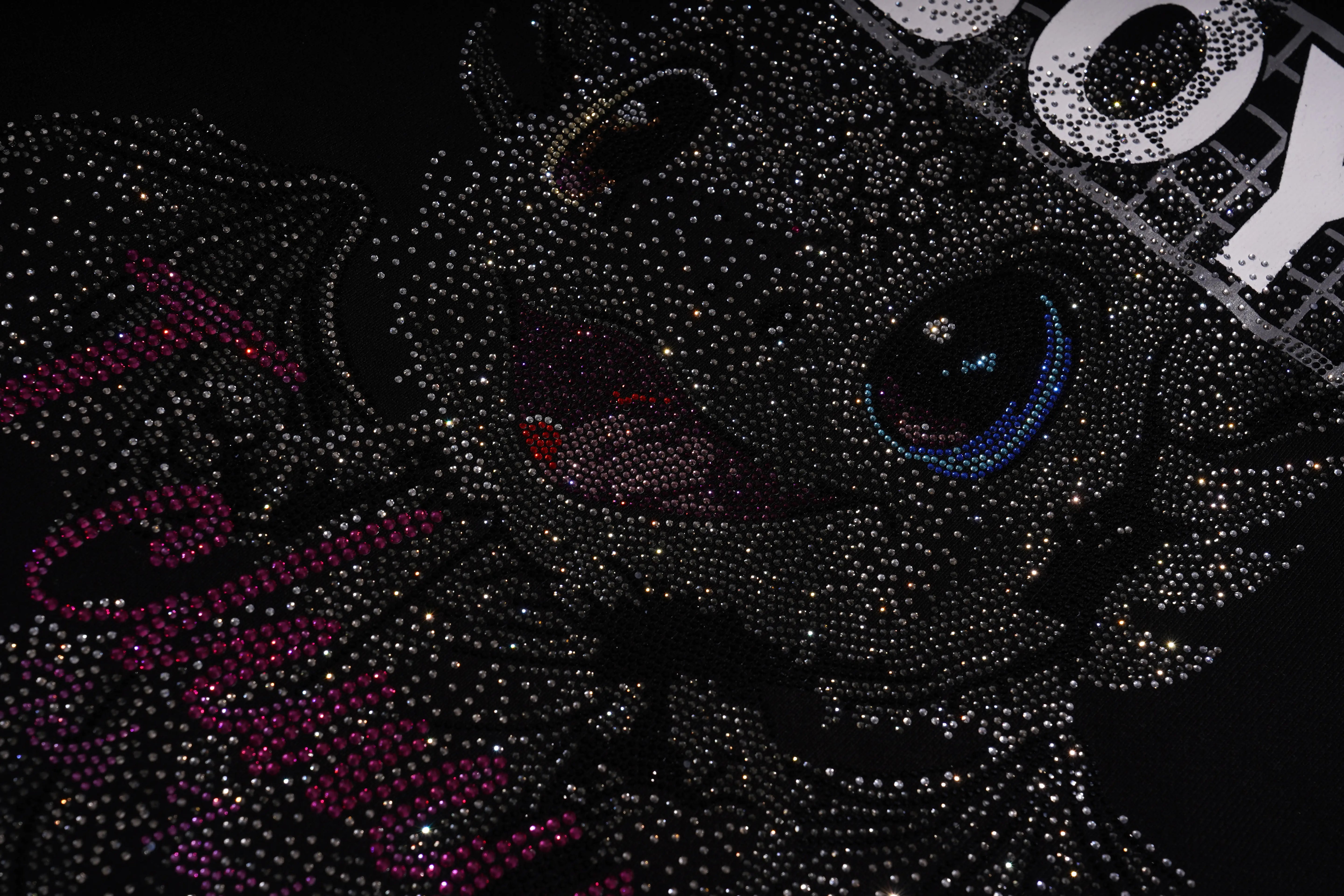 Close-up of a rhinestone-embellished black cat toy with visible branding.