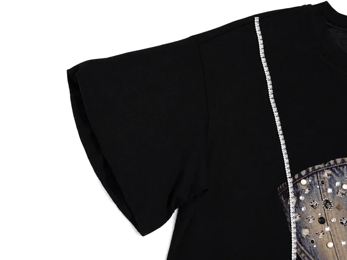 Close-up of a black short-sleeve top with a vertical line of clear rhinestones down the side and a decorative denim panel with metallic studs on the lower right, shown on a white background. TCH Rhinestone Denim Corset Graphic Oversized T-Shirt