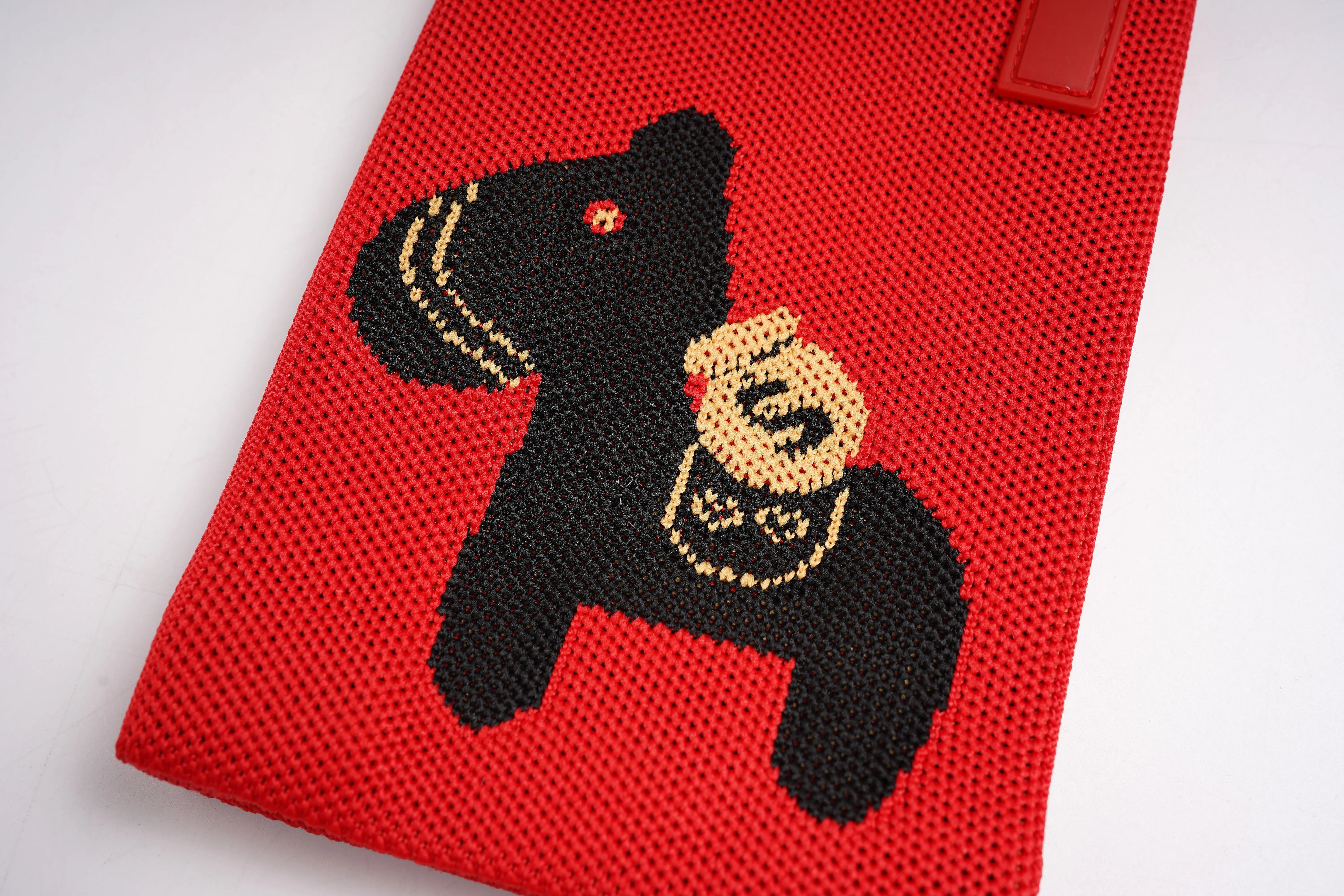 Red knitted pouch with a black bear design holding a gold coin on a white background, TCH Rhinestone Floral Black Horse Red Crossbody & Handbag