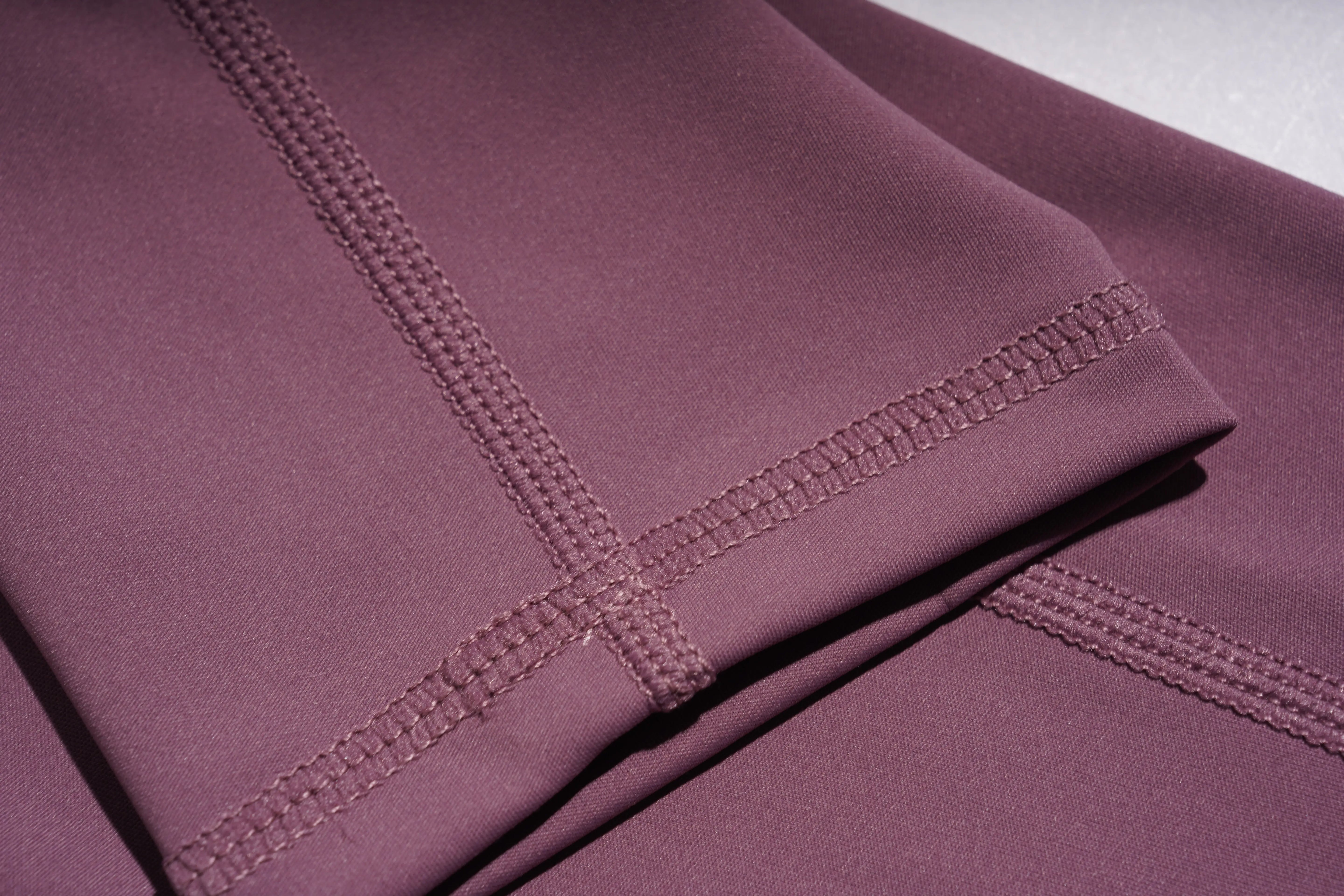 Close-up of a folded piece of purple fabric with visible stitching.