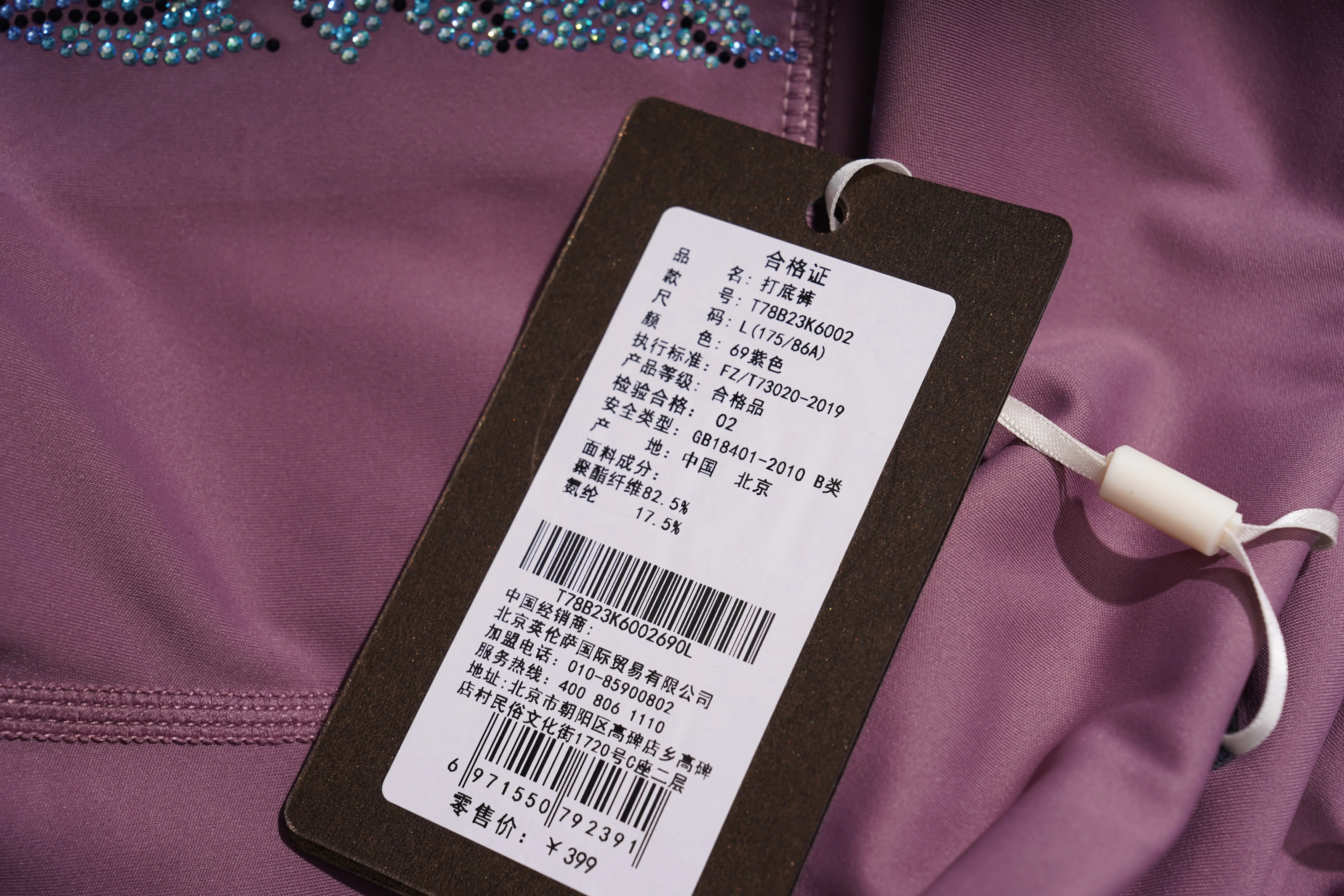 Clothing tag with text and barcodes on a purple garment
