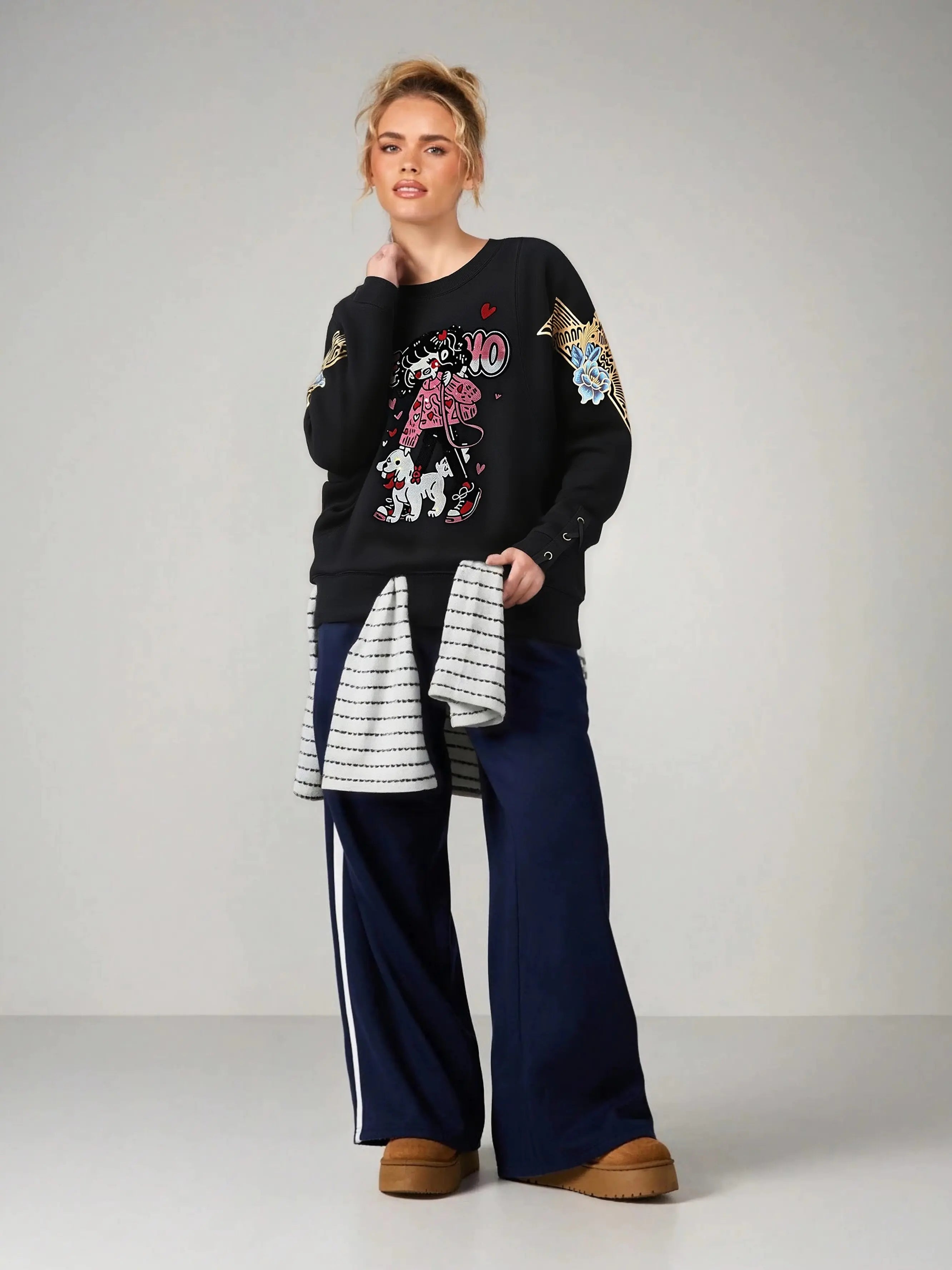Person wearing a black sweater with colorful designs and blue pants on a plain background, TCH Rhinestone Girl & Dog Graphic Crewneck Sweatshirt