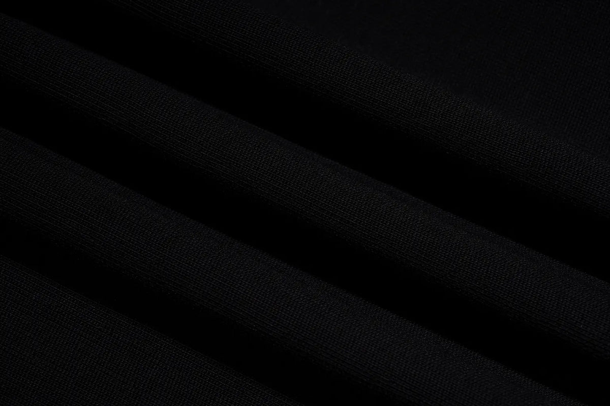 A close-up of black fabric with soft diagonal folds showing a fine woven texture. TCH Rhinestone Graphic Black Crewneck Sweatshirt
