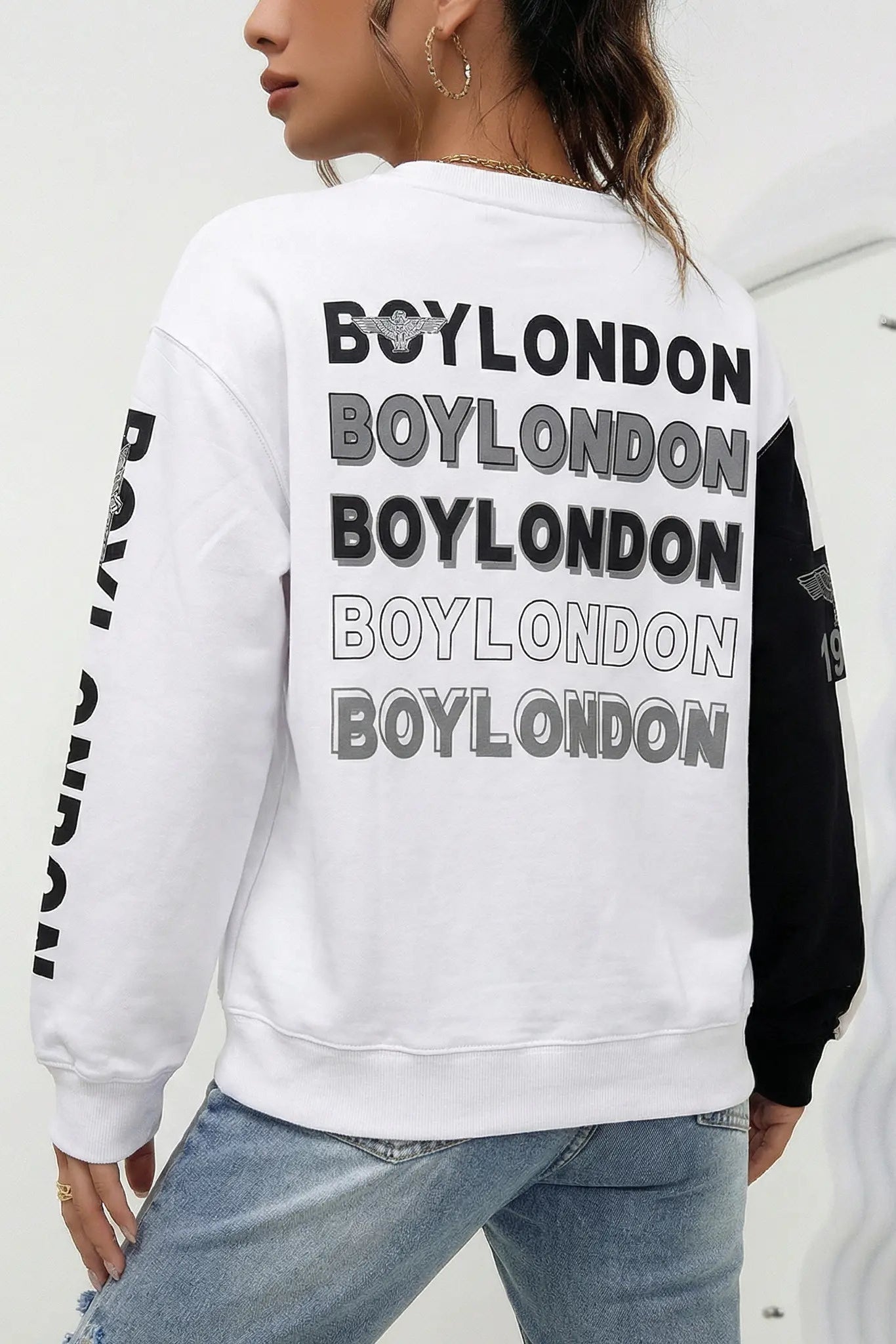 Person wearing a white sweatshirt with 'BOYLONDON' branding on the back. TCH Rhinestone Hello Kitty BOYLONDON Sweatshirt