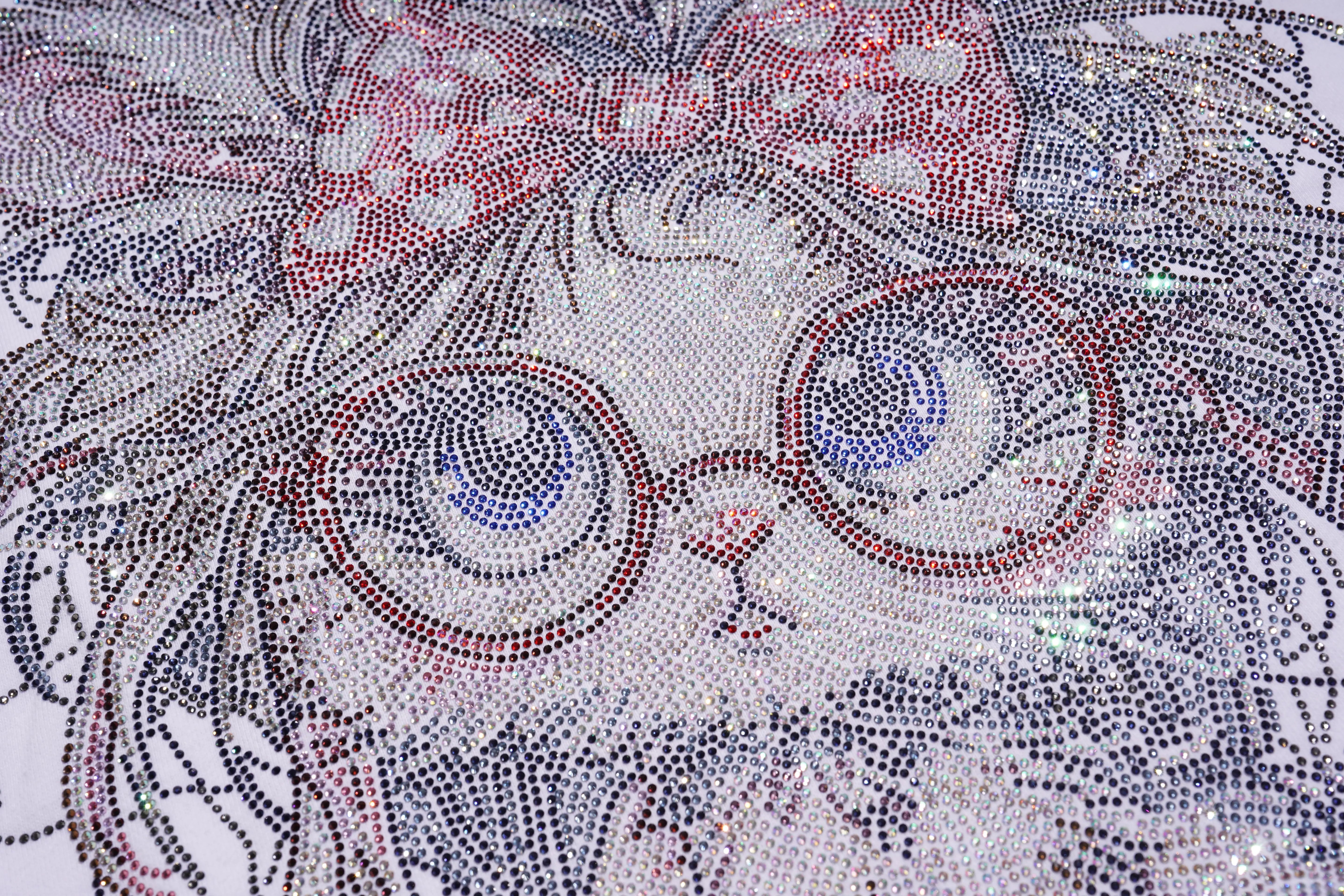 Close-up of a mosaic pattern with circular designs in red, blue, and white. TCH Rhinestone Hello Kitty BOYLONDON Sweatshirt