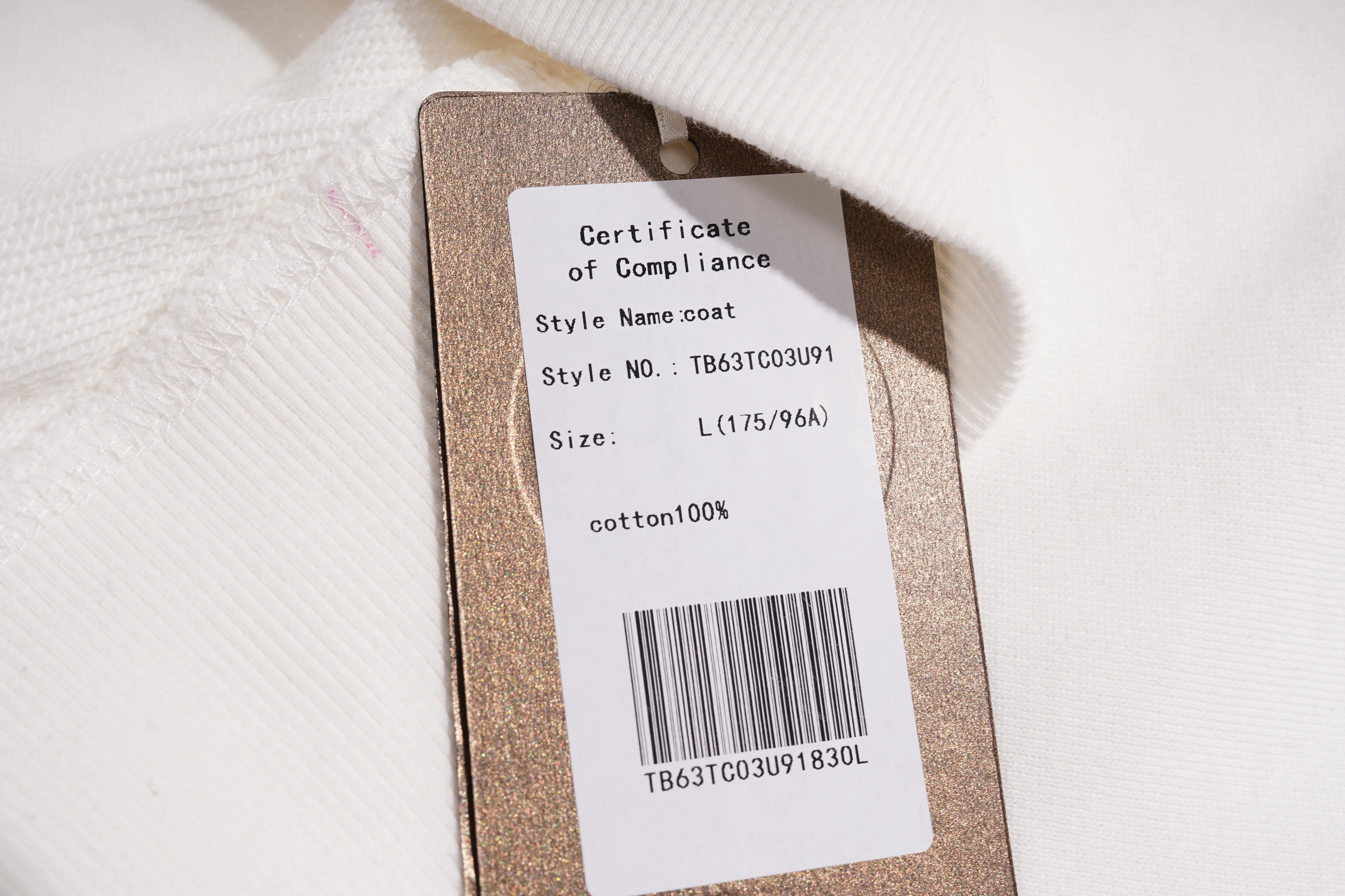 Clothing label with certificate of compliance on a textured fabric background
