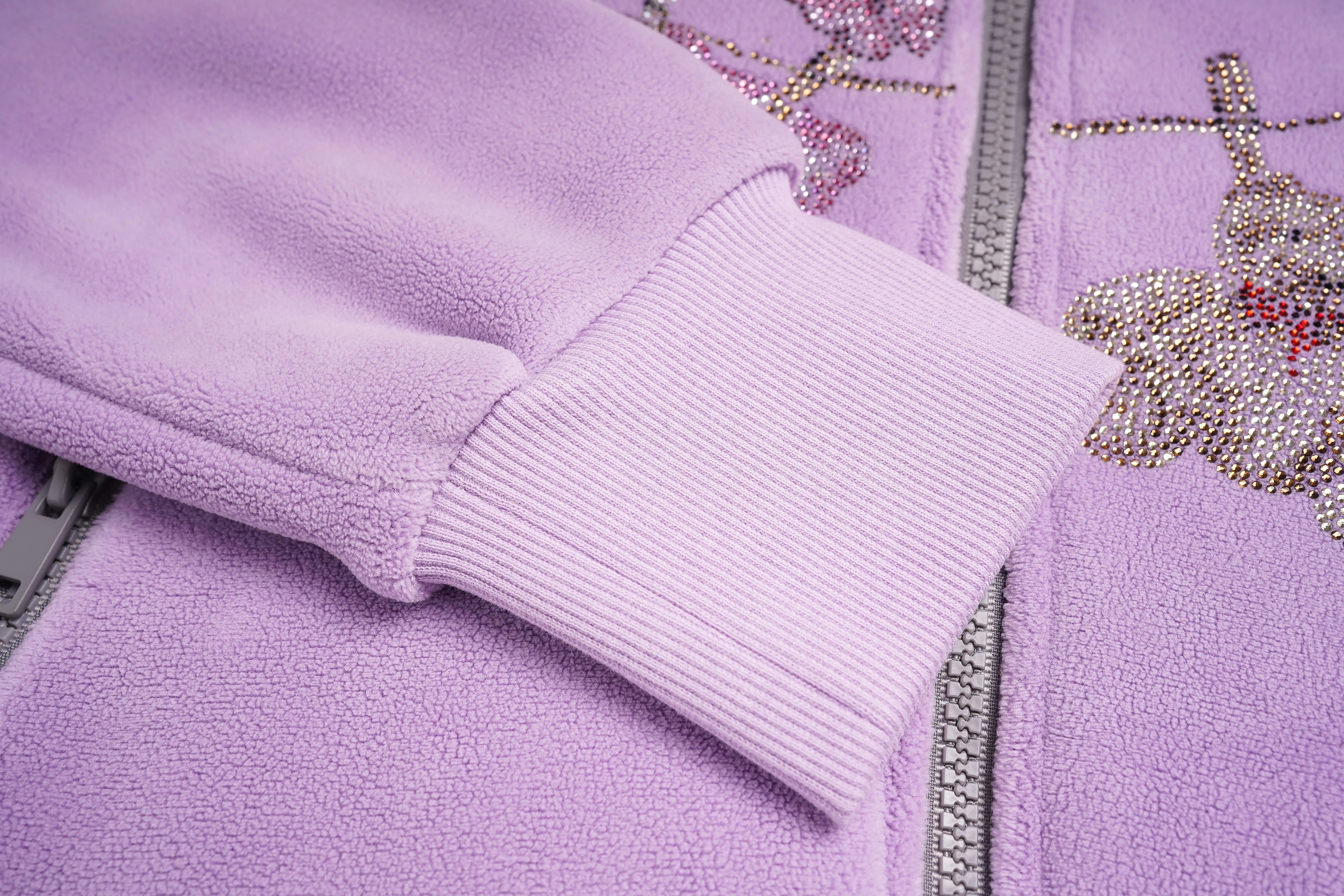Close-up of a purple fleece jacket with embroidered design on a matching background, TCH Rhinestone Laundry Line Purple Zip Turtleneck Set