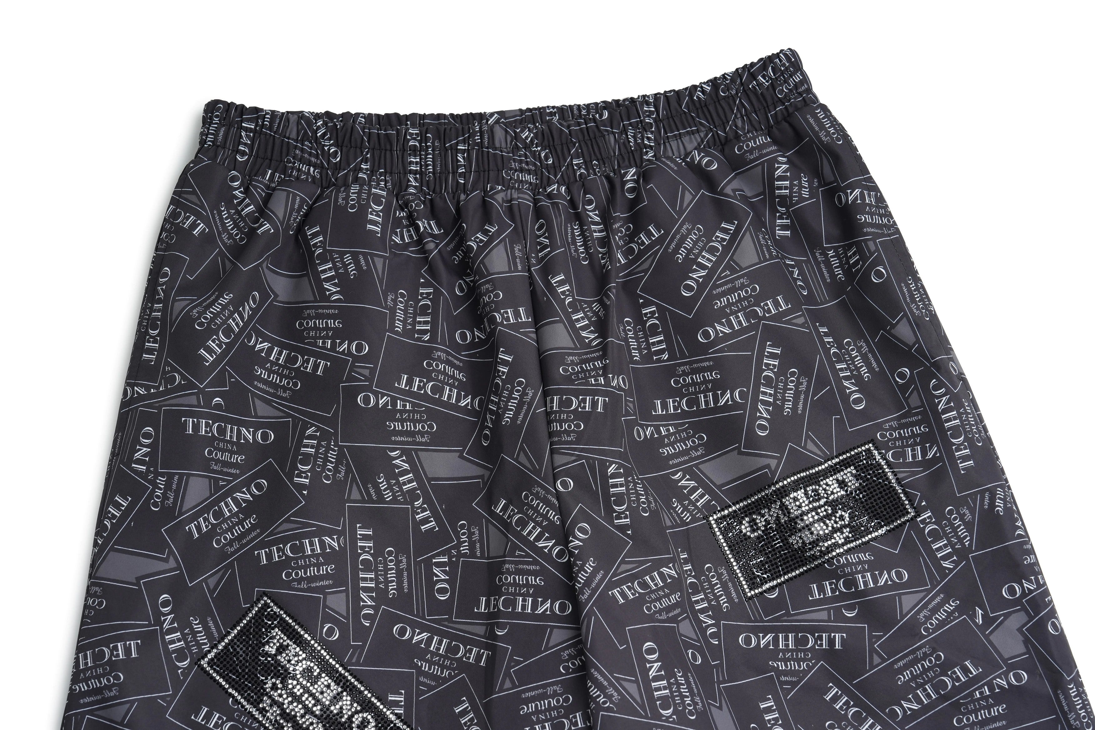Dark gray shorts with text pattern on a white background, TCH Rhinestone Logo Patch Wide-Leg Track Pants