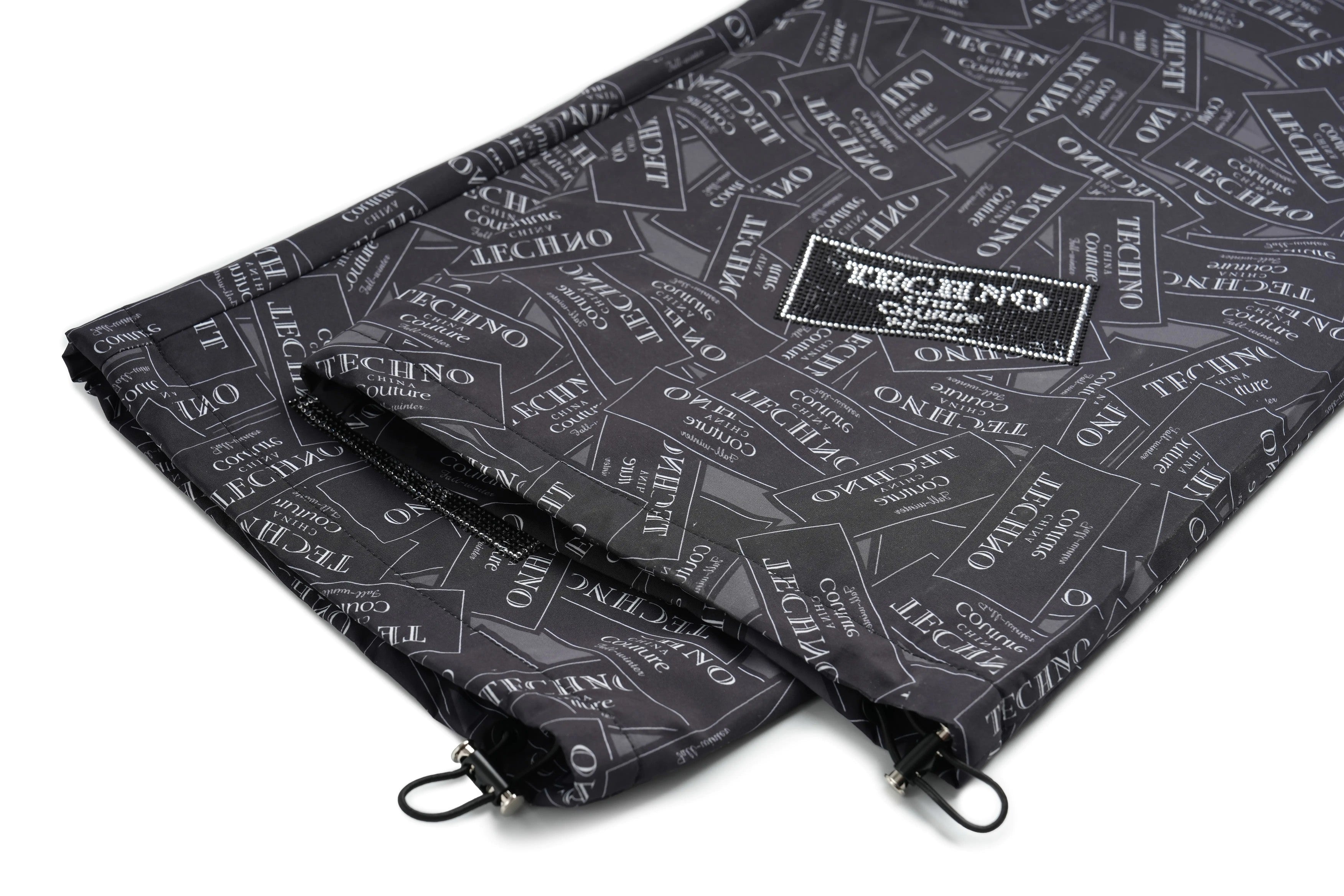 Two black patterned bags with a visible brand logo on a white background, TCH Rhinestone Logo Patch Wide-Leg Track Pants