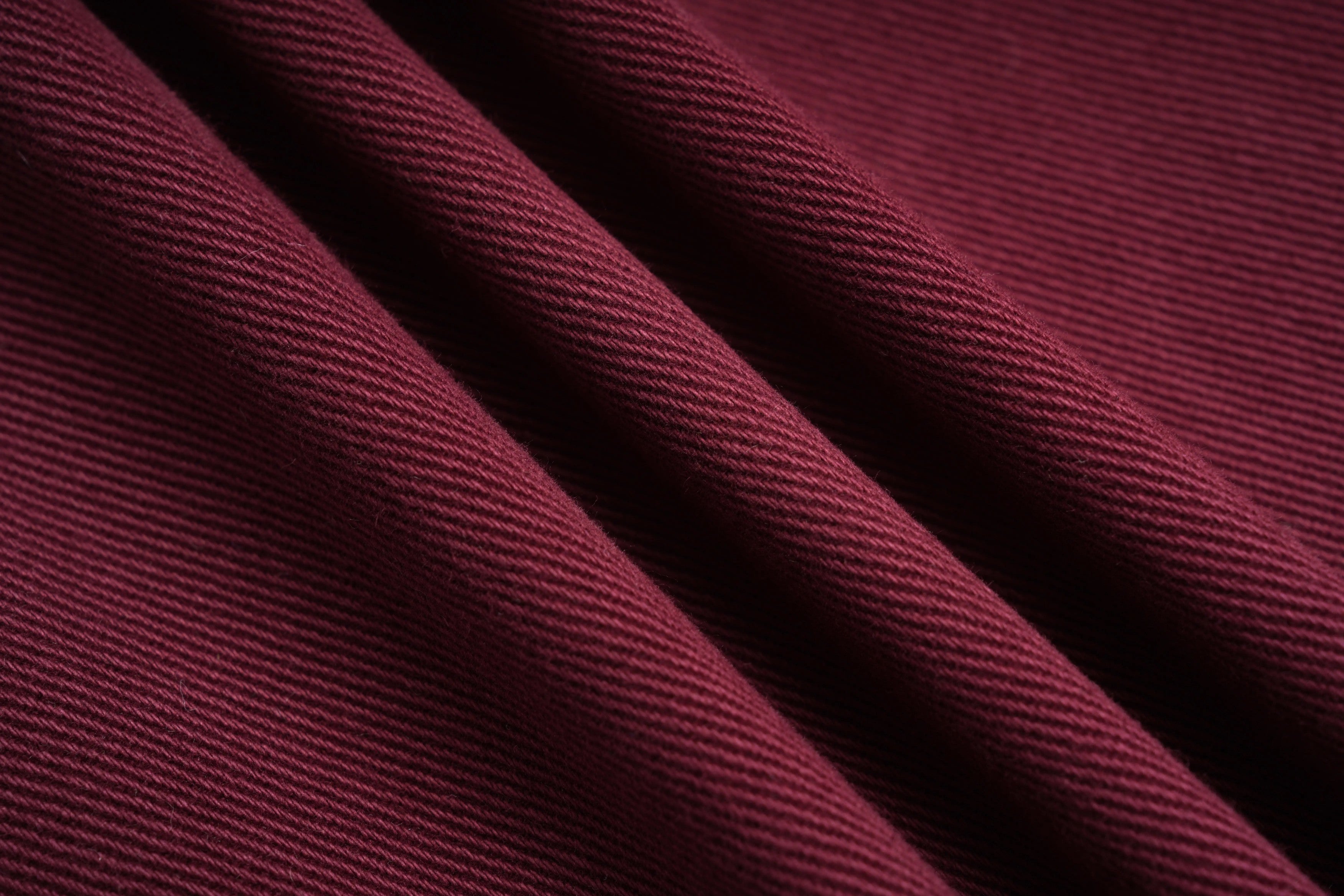 Close-up of maroon fabric with visible texture, TCH Rhinestone Logo Red Denim Jeans