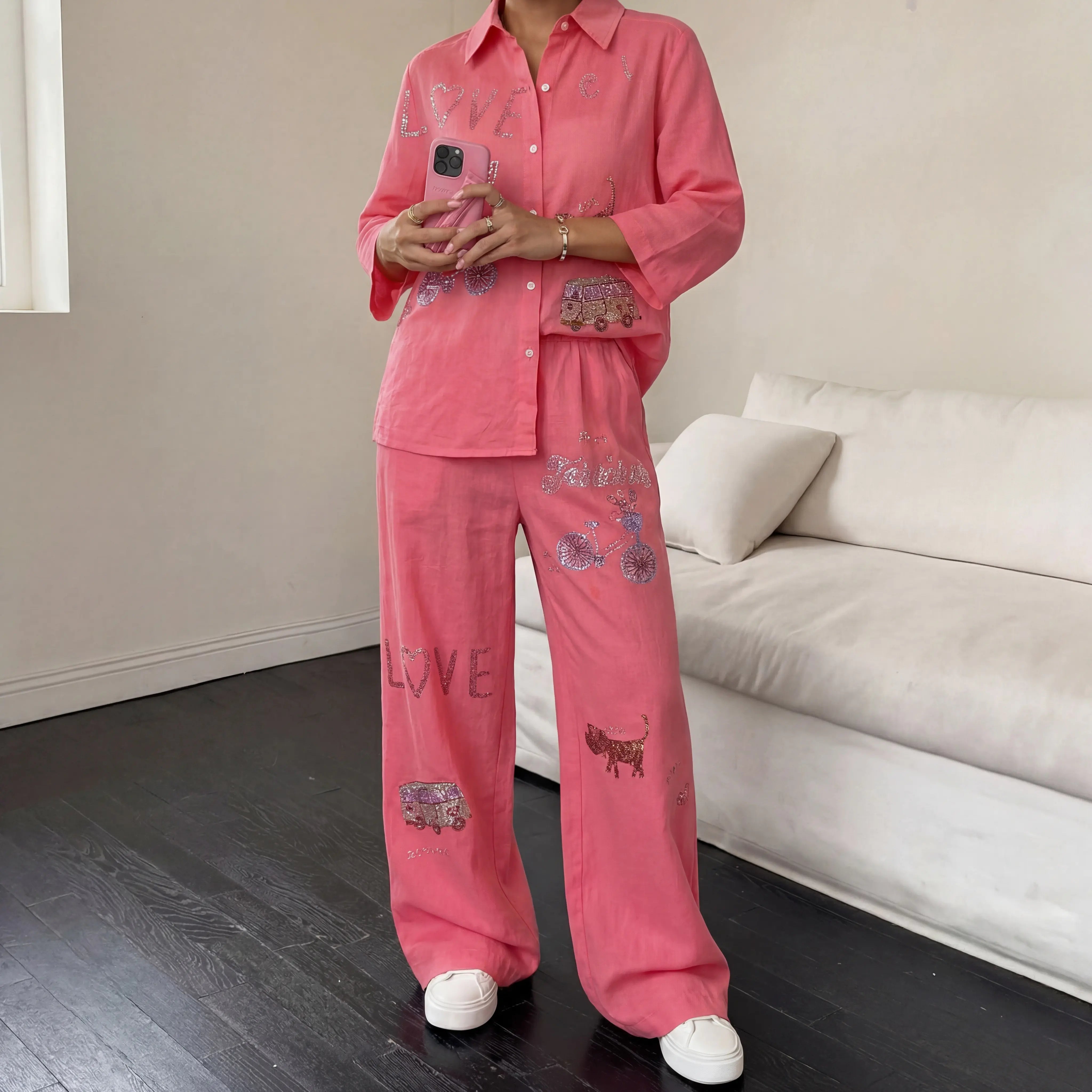 Person wearing pink pajama set with cat designs in a living room. TCH Rhinestone Love Lucky Pig Set