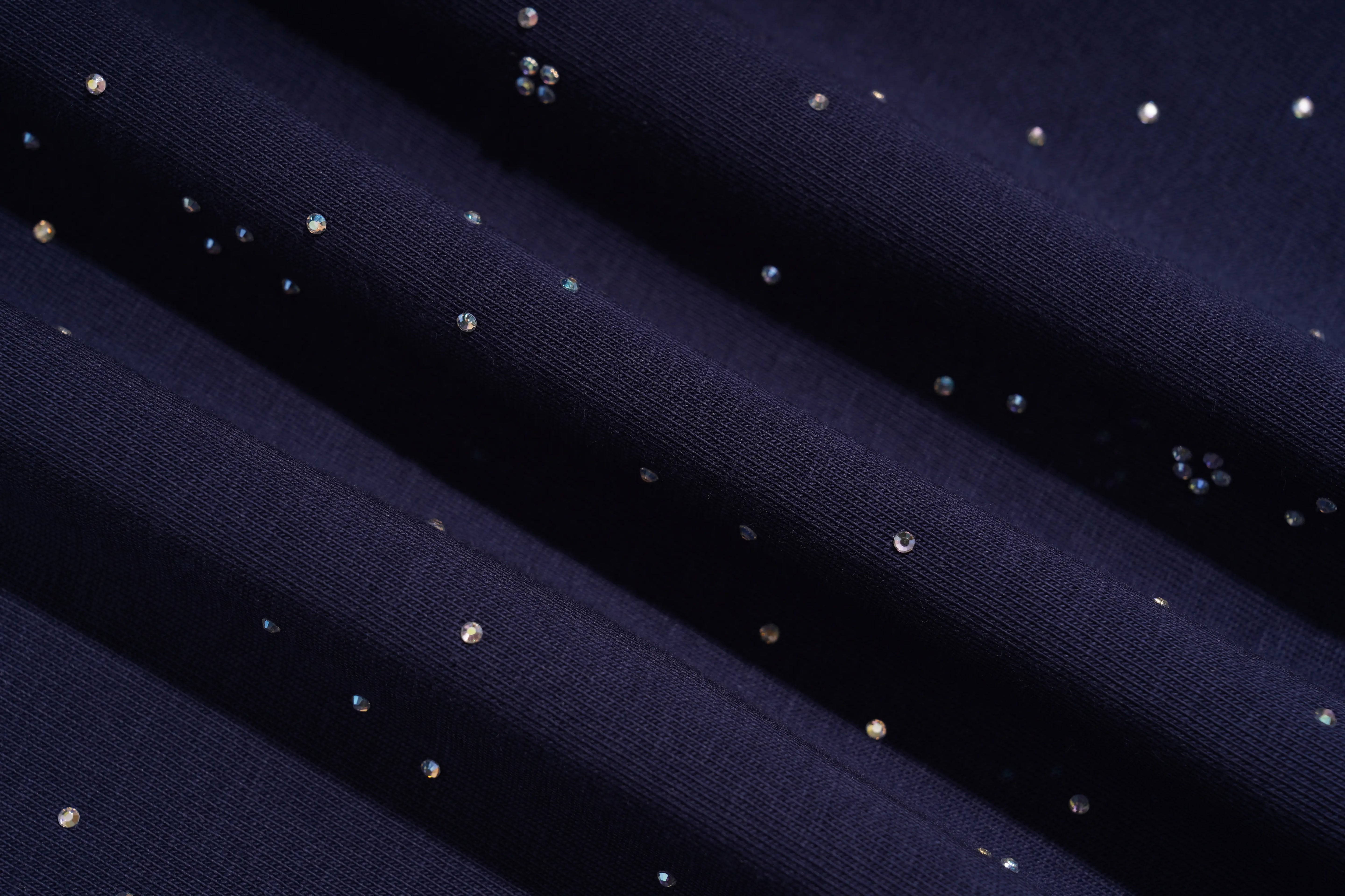 Close-up of dark navy fabric with scattered small iridescent rhinestones catching the light in diagonal folds. TCH Rhinestone Pegasus Wing Graphic Navy Blue T-Shirt