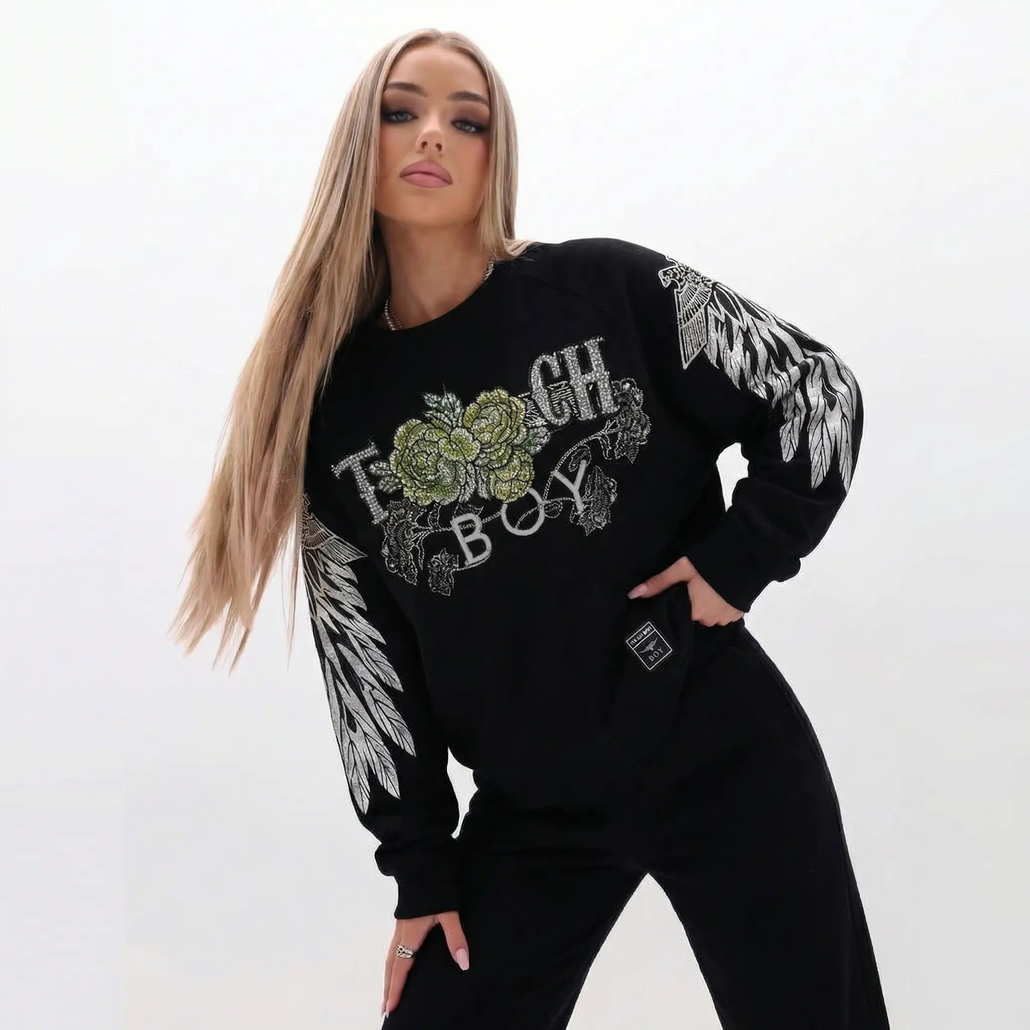 Woman wearing a black sweatshirt with floral and text design on a white background, TCH Rhinestone Peony Wing Graphic Crew Neck Sweatshirt