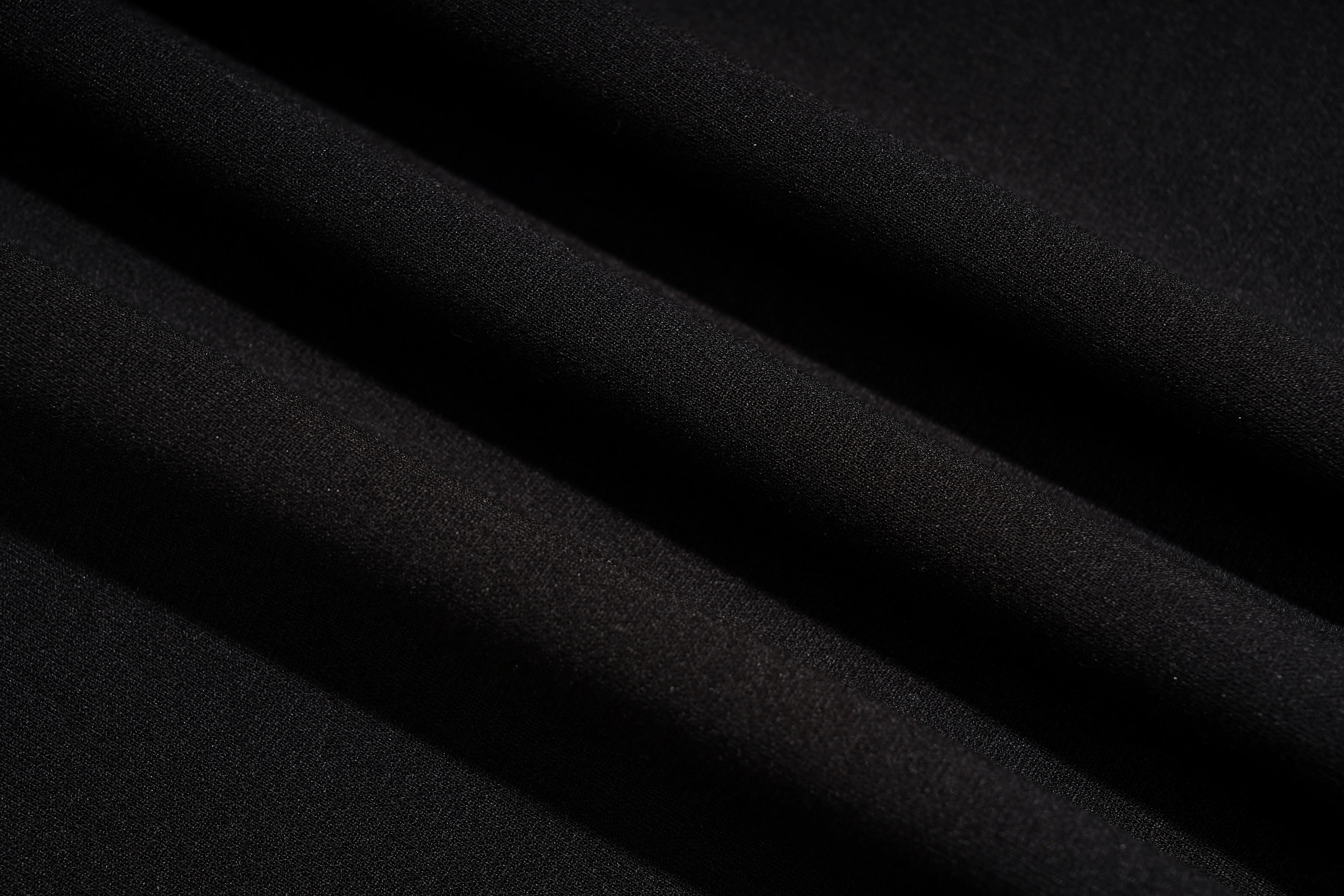 A close-up of draped black fabric with soft diagonal folds showing a fine textured weave. TCH Rhinestone Pig Graphic Long Sweatshirt Dress