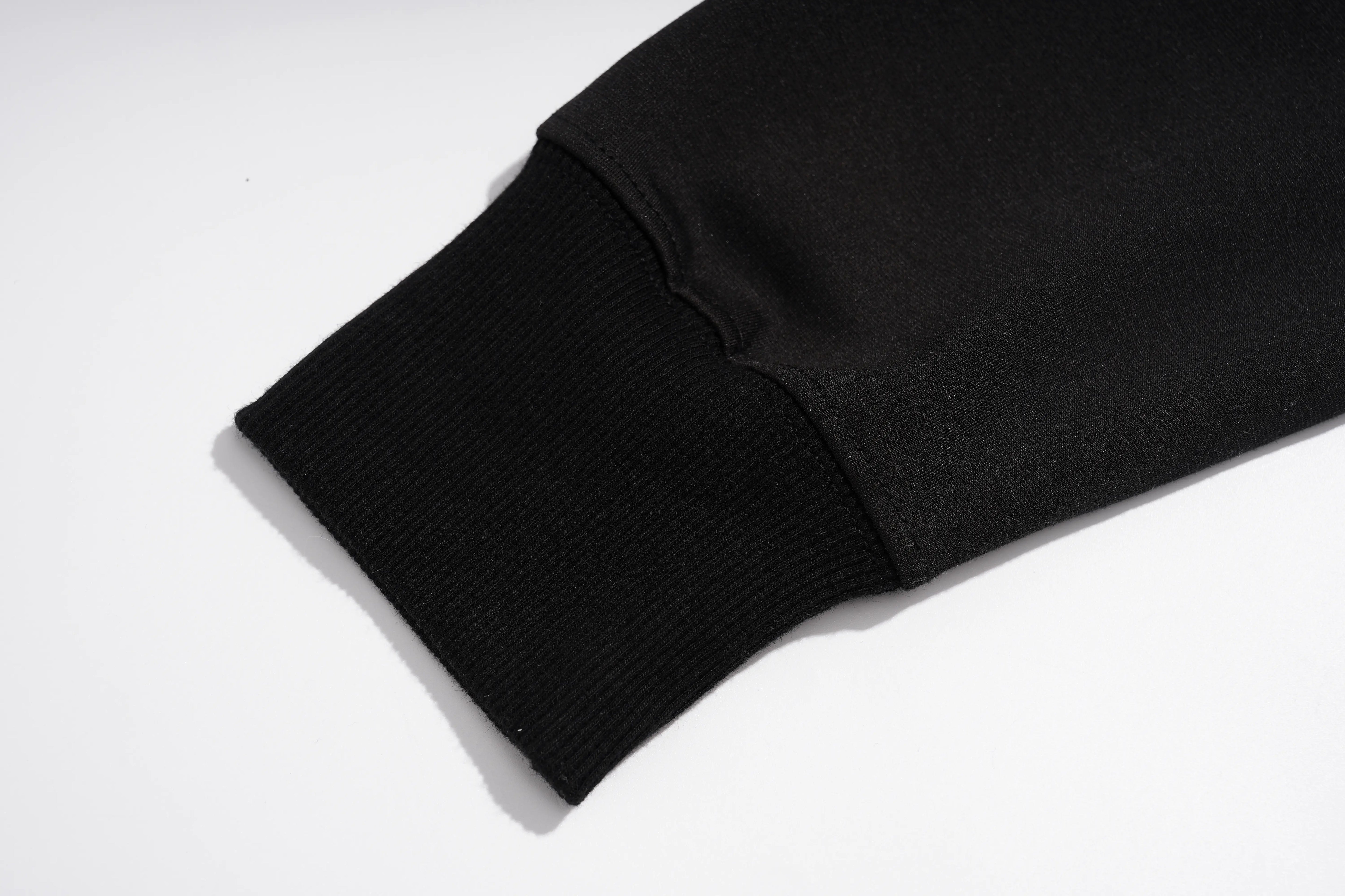 Close-up of a black ribbed knit sleeve cuff on a white background. TCH Rhinestone Pig Graphic Long Sweatshirt Dress