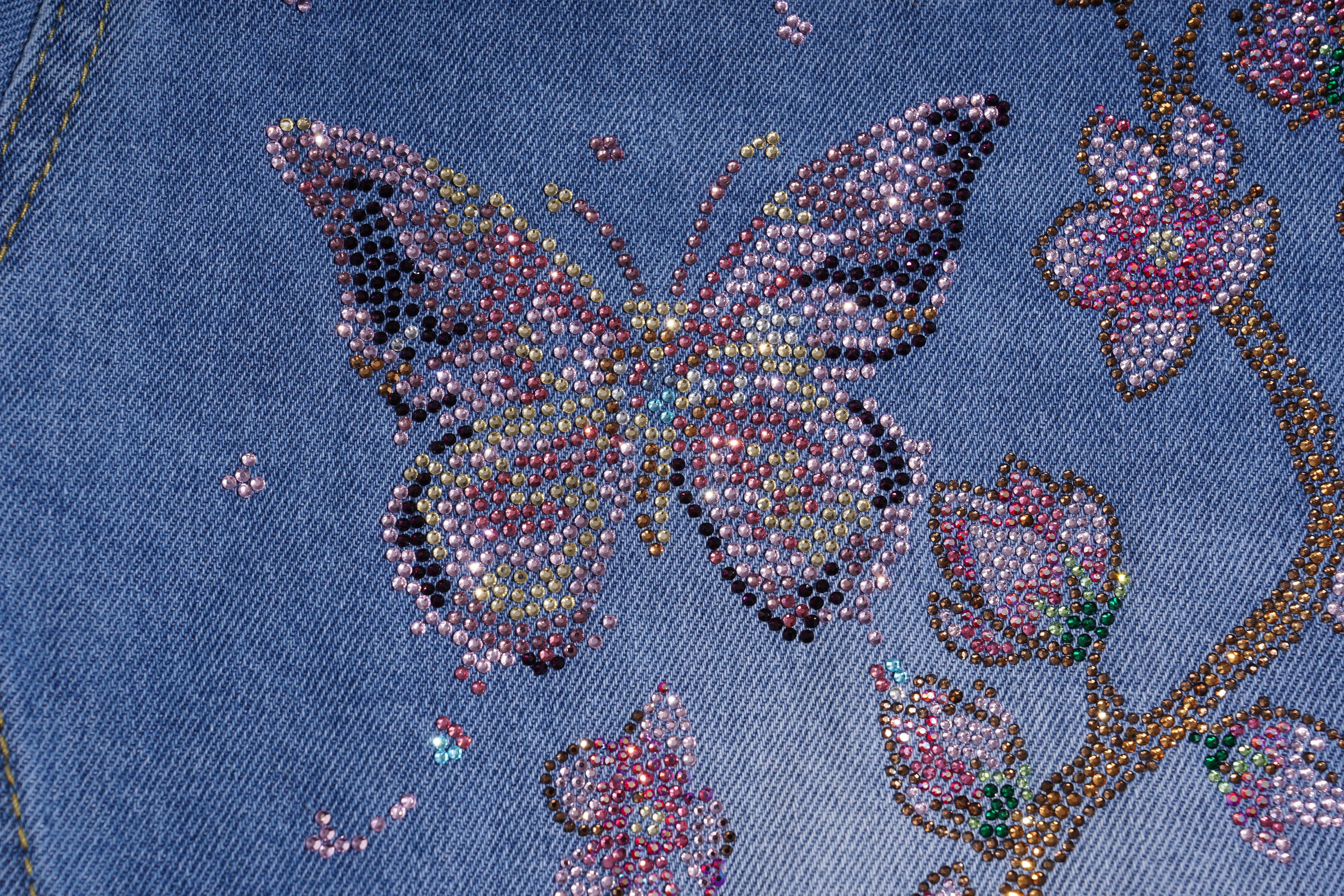 Butterfly design with rhinestones on a blue fabric background, TCH Rhinestone Plum Blossom Tree Distressed Denim Jeans