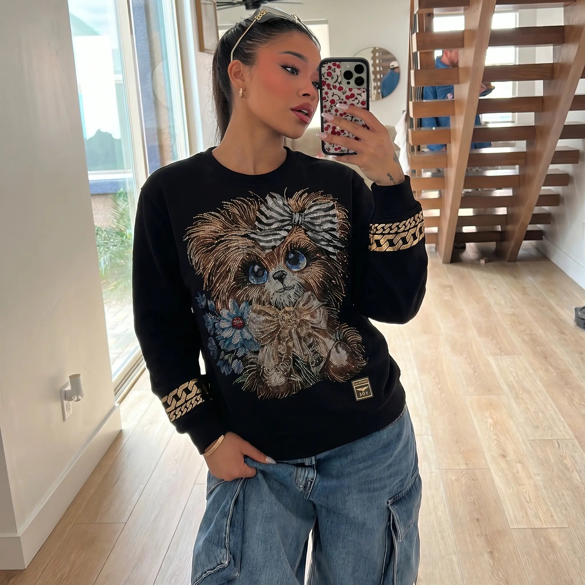 Person wearing a black sweater with a dog graphic in a home setting, TCH Rhinestone Puppy Black Streetwear Sweatshirt