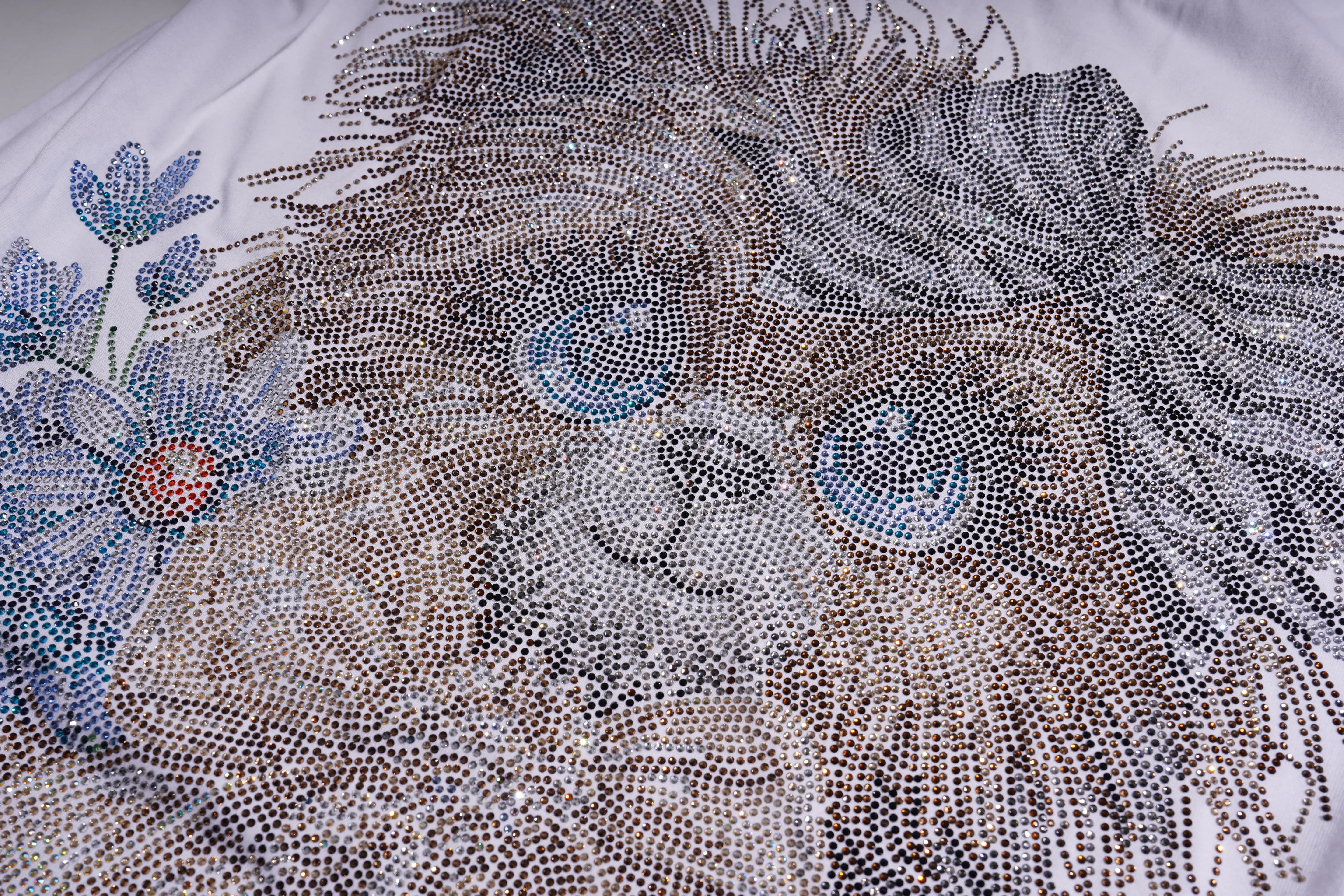 Close-up of a lion embroidered with intricate details on fabric.