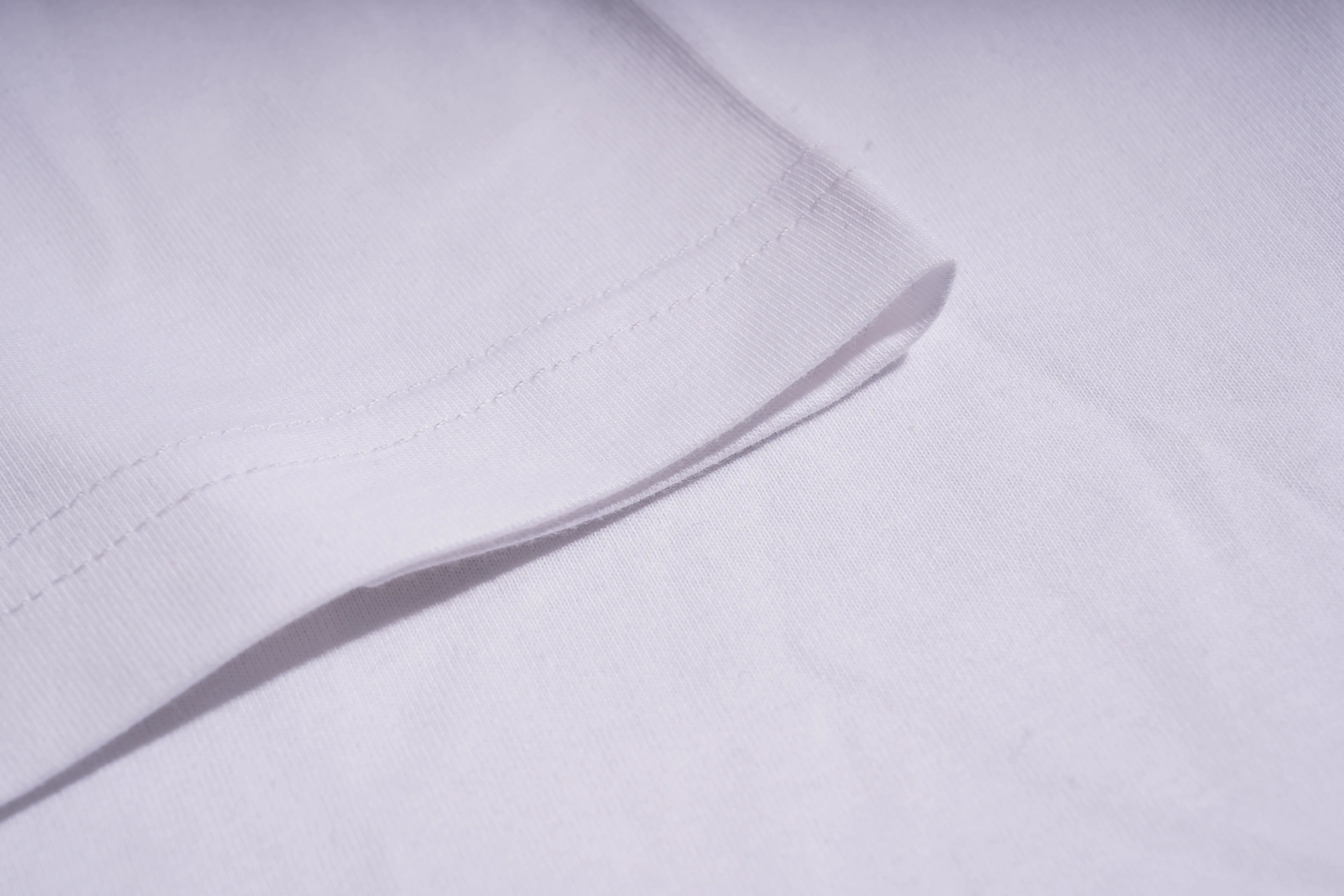 Close-up of a white shirt with a subtle pattern on a light gray background