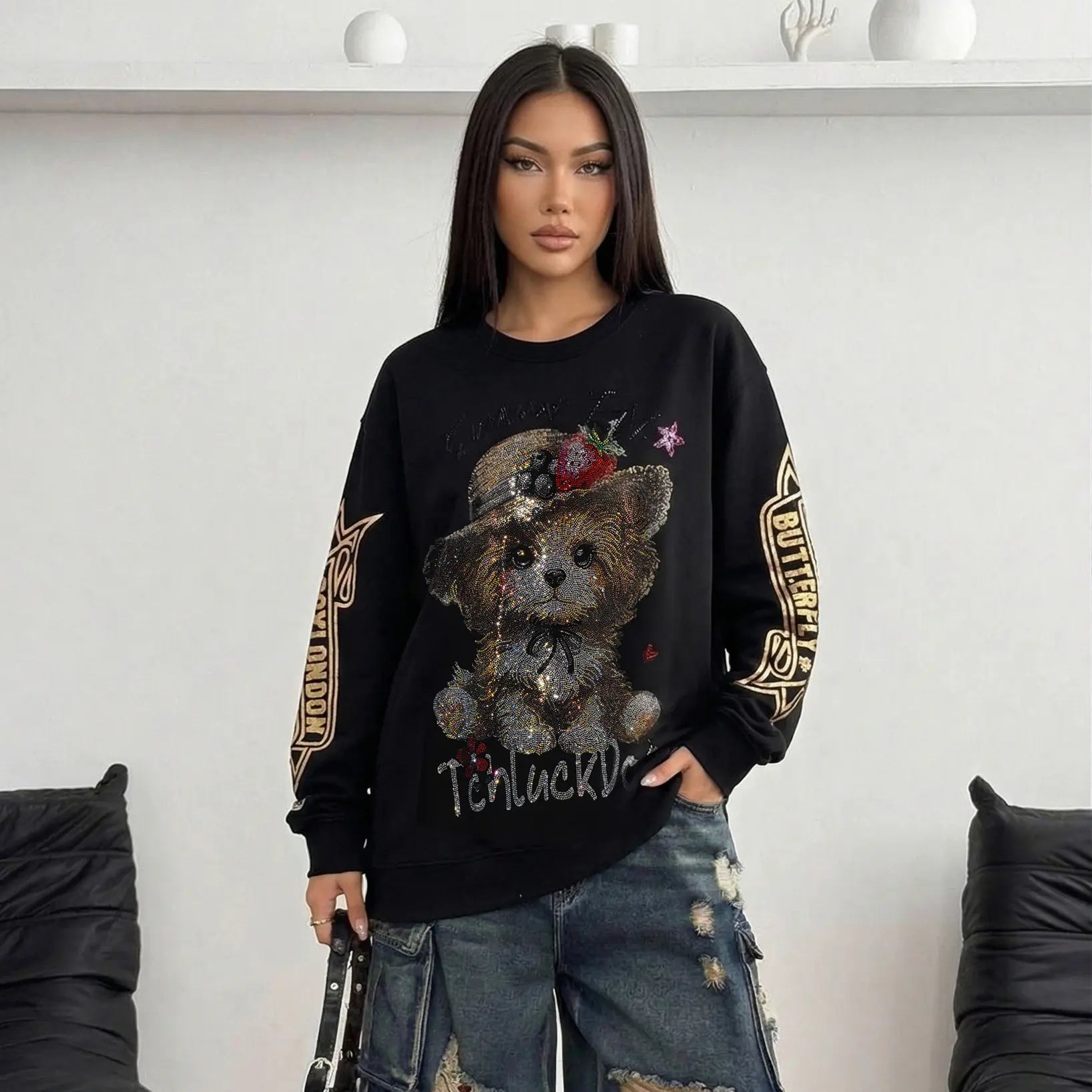Person wearing a black sweater with a teddy bear design and 'Butterfly' text. TCH Rhinestone Puppy Graphic Sweatshirt-