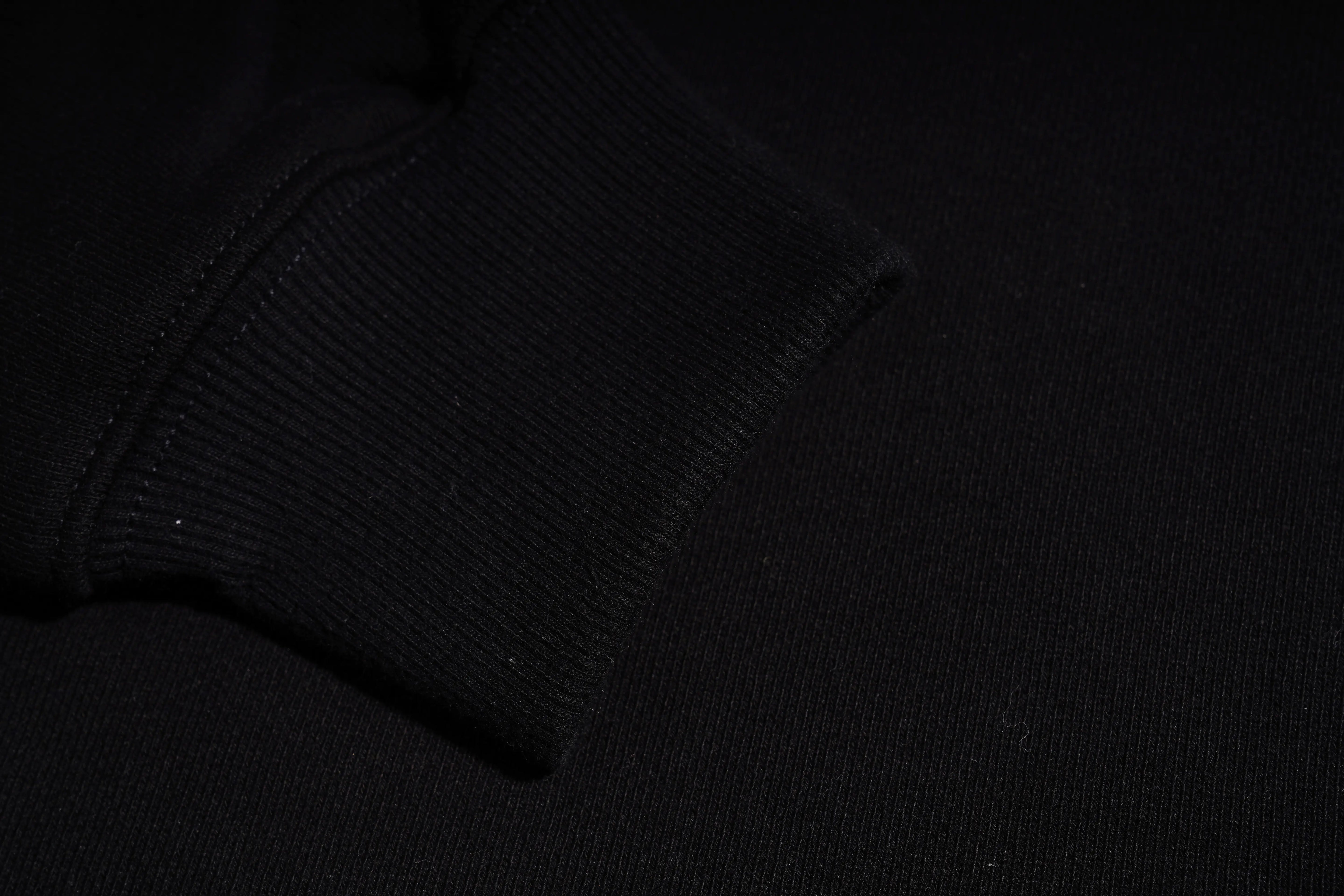 Close-up of a black textured sweater on a dark background, TCH Rhinestone Puppy Graphic Sweatshirt-