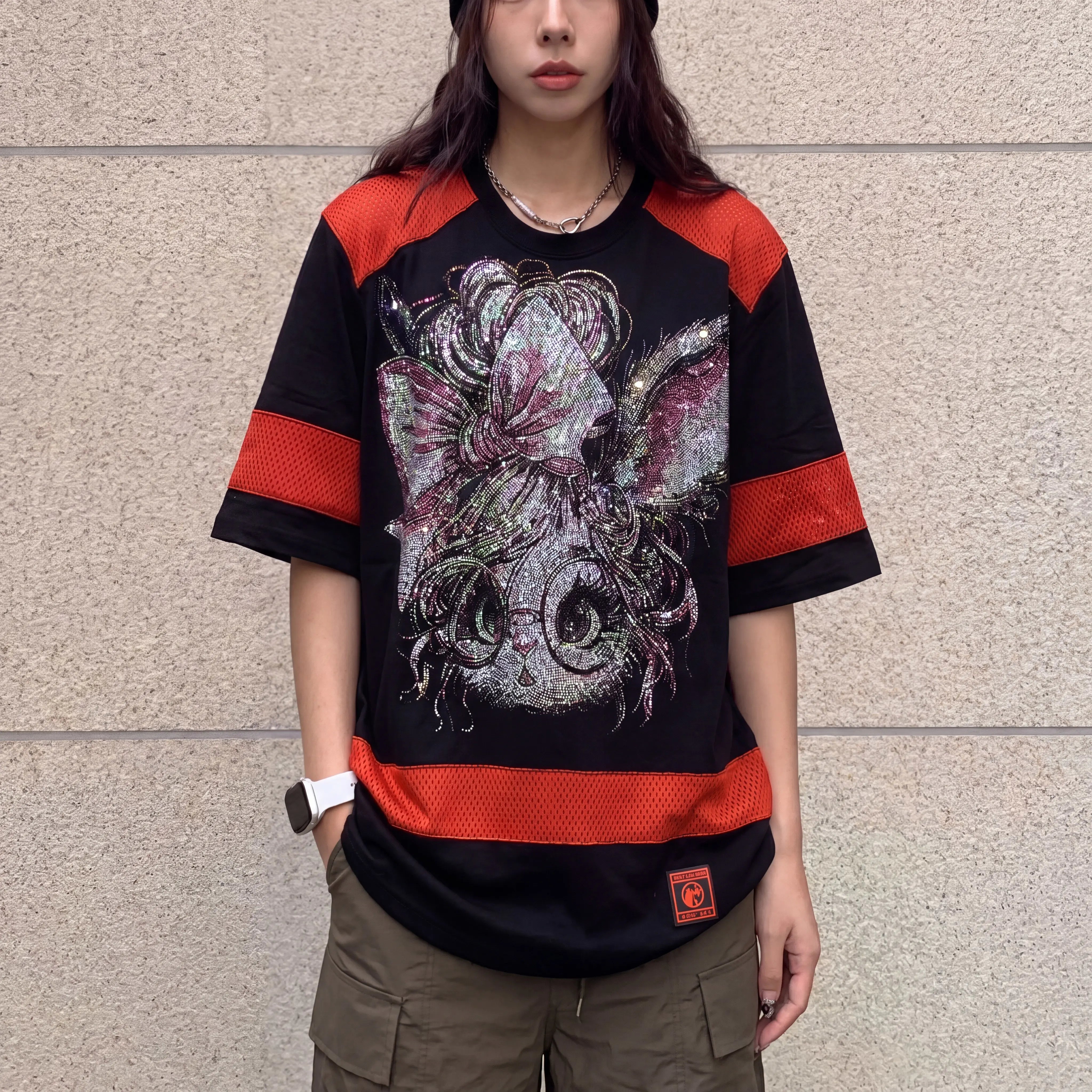 Person wearing a black and red graphic t-shirt with a design on a beige wall background, TCH Rhinestone Rabbit Black Red Jersey