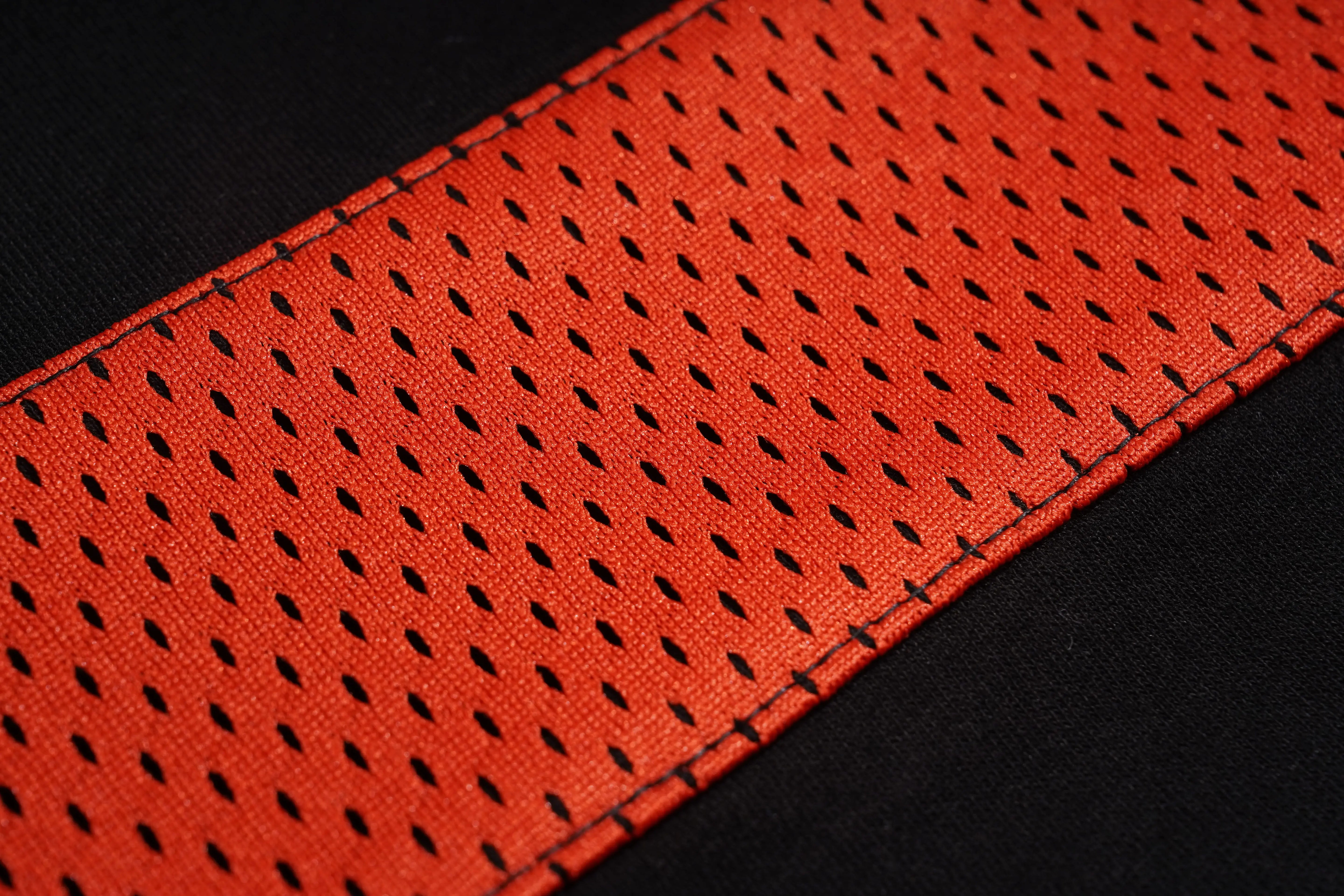 Close-up of a red perforated belt on a black background, TCH Rhinestone Rabbit Black Red Jersey