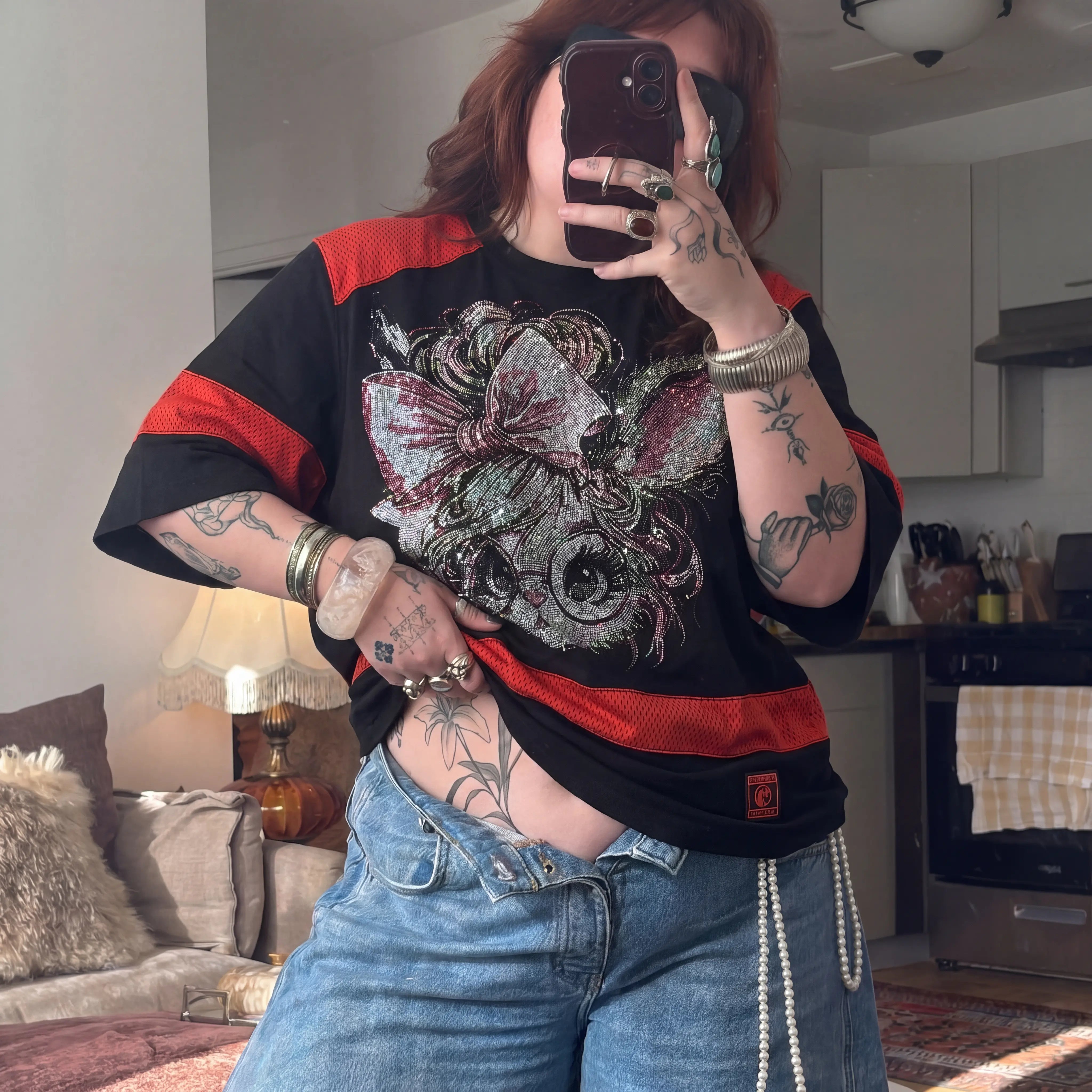 Person taking a mirror selfie wearing a black and red shirt with a floral design, in a casual indoor setting. TCH Rhinestone Rabbit Black Red Jersey