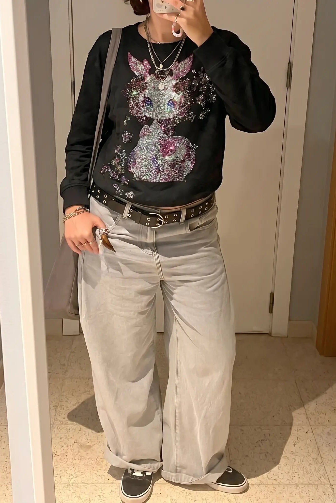 Person taking a mirror selfie wearing a black sweatshirt with a colorful graphic design, light gray pants, and black sneakers. TCH Rhinestone Snake Black Crewneck Sweatshirt